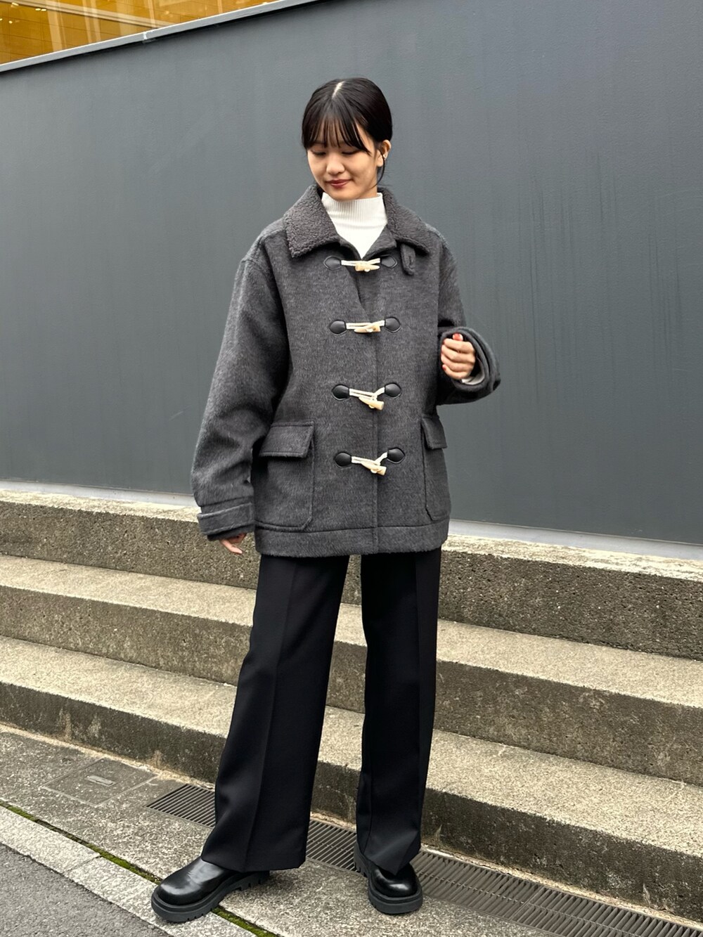 グレー系のその他アウター、ブラック系のスラックス、ブラック系のブーツを着用したレディースの秋コーディネートの2枚目の写真