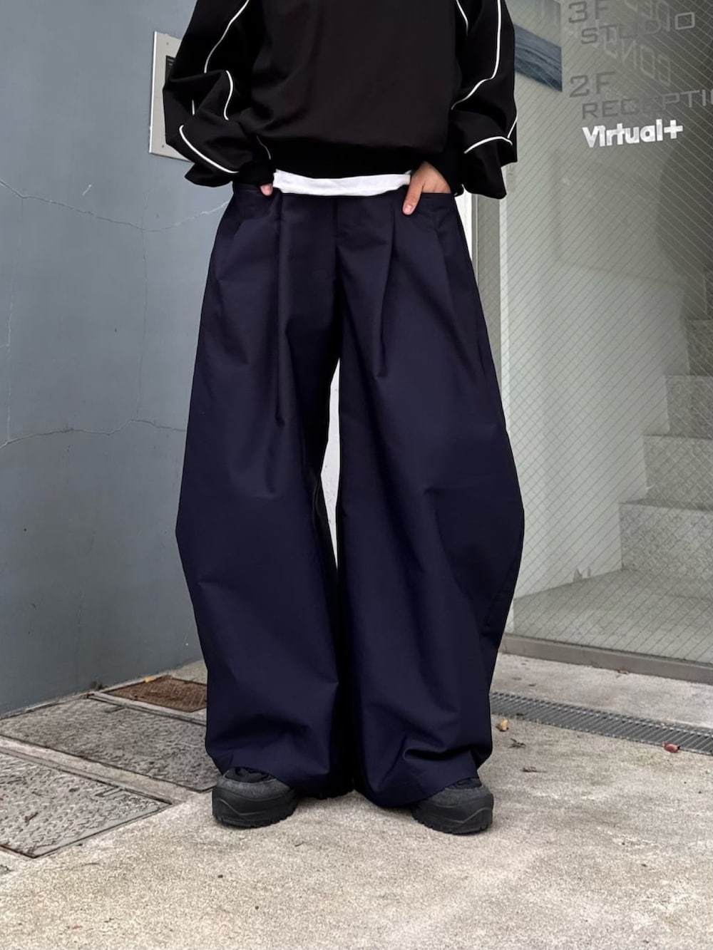 ブルー系のその他パンツ、ブラック系のスウェット、ブラック系のサングラスを着用したレディースの春コーディネートの2枚目の写真