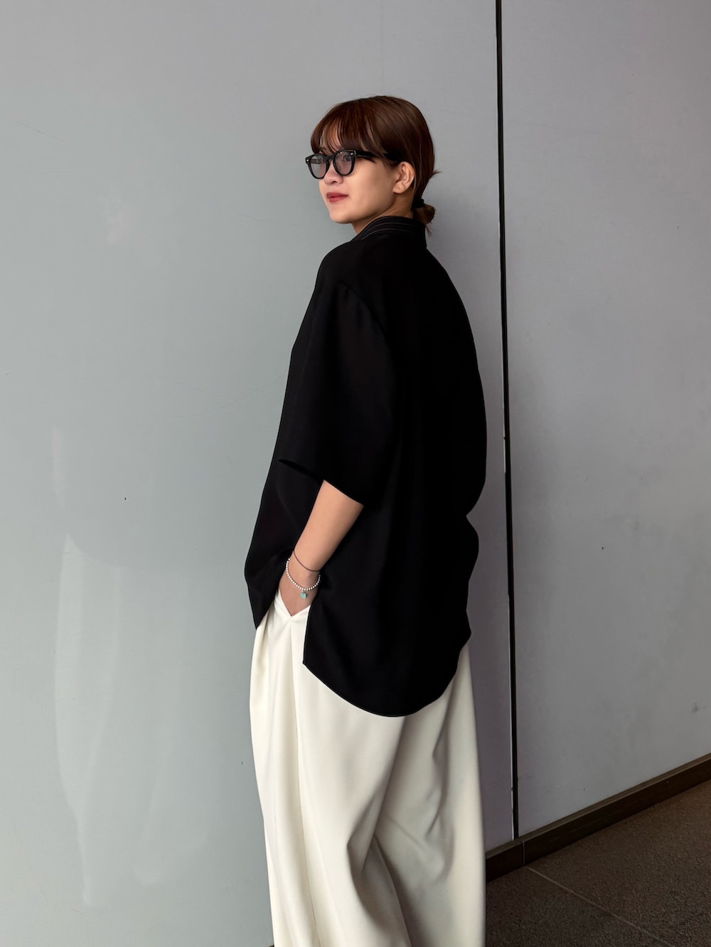 ブラック系のシャツ/ブラウス、グレー系のスラックスを着用したレディースの春コーディネートの7枚目の写真