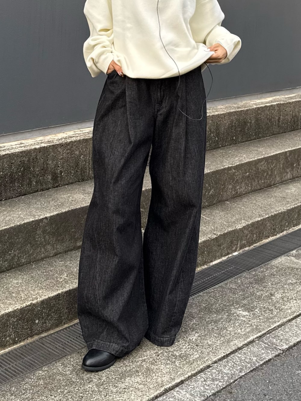 グレー系のニット/セーター、ブラック系のデニムパンツを着用したレディースの秋コーディネートの3枚目の写真