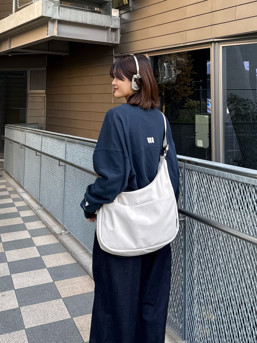 ブルー系のスウェット、グレー系のショルダーバッグ、ブルー系のデニムパンツを着用したレディースの冬コーディネートの4枚目の写真