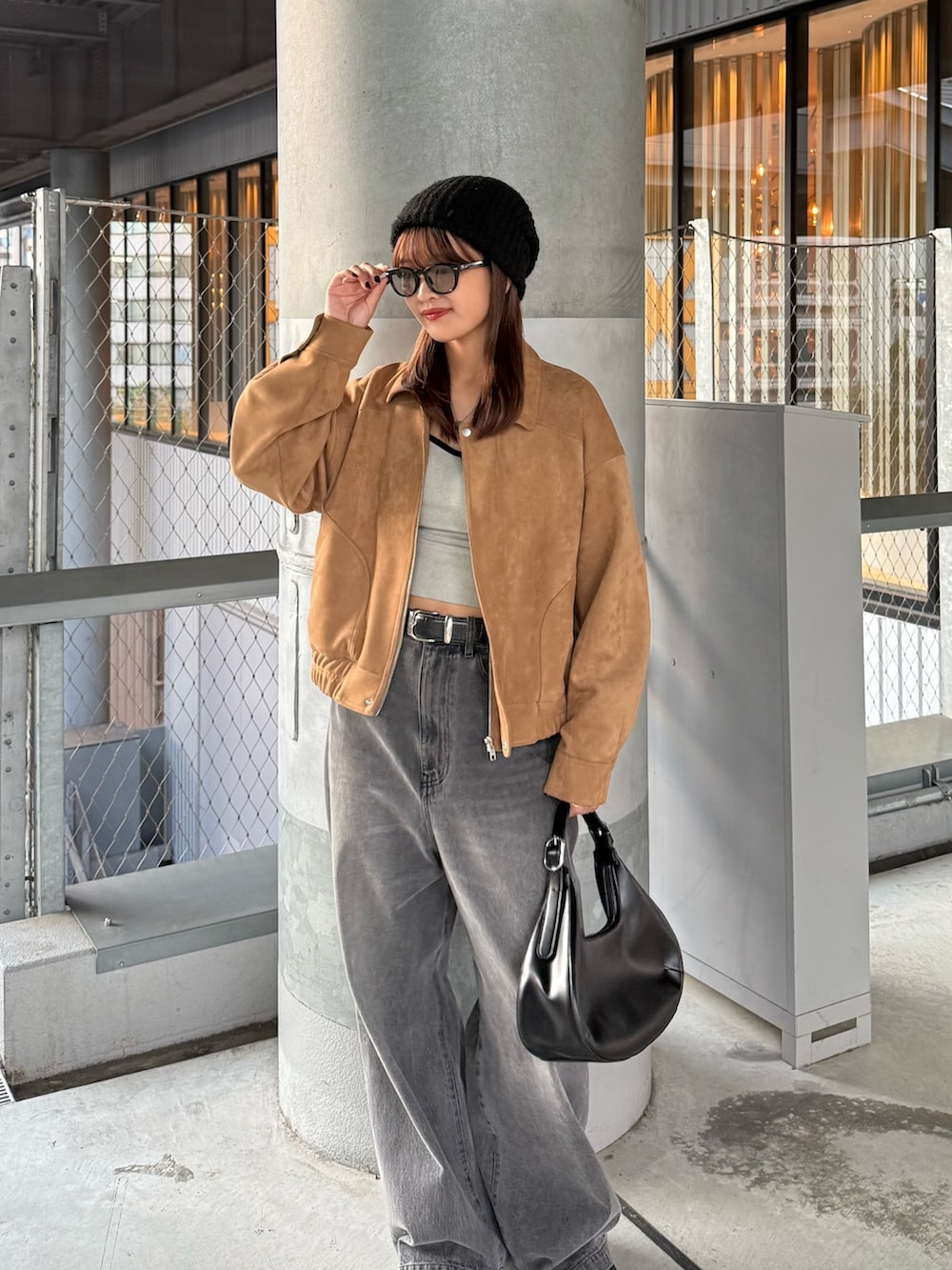 ブラウン系のブルゾン、ブラック系のデニムパンツ、ブラック系のベルトを着用したレディースの秋コーディネートの3枚目の写真