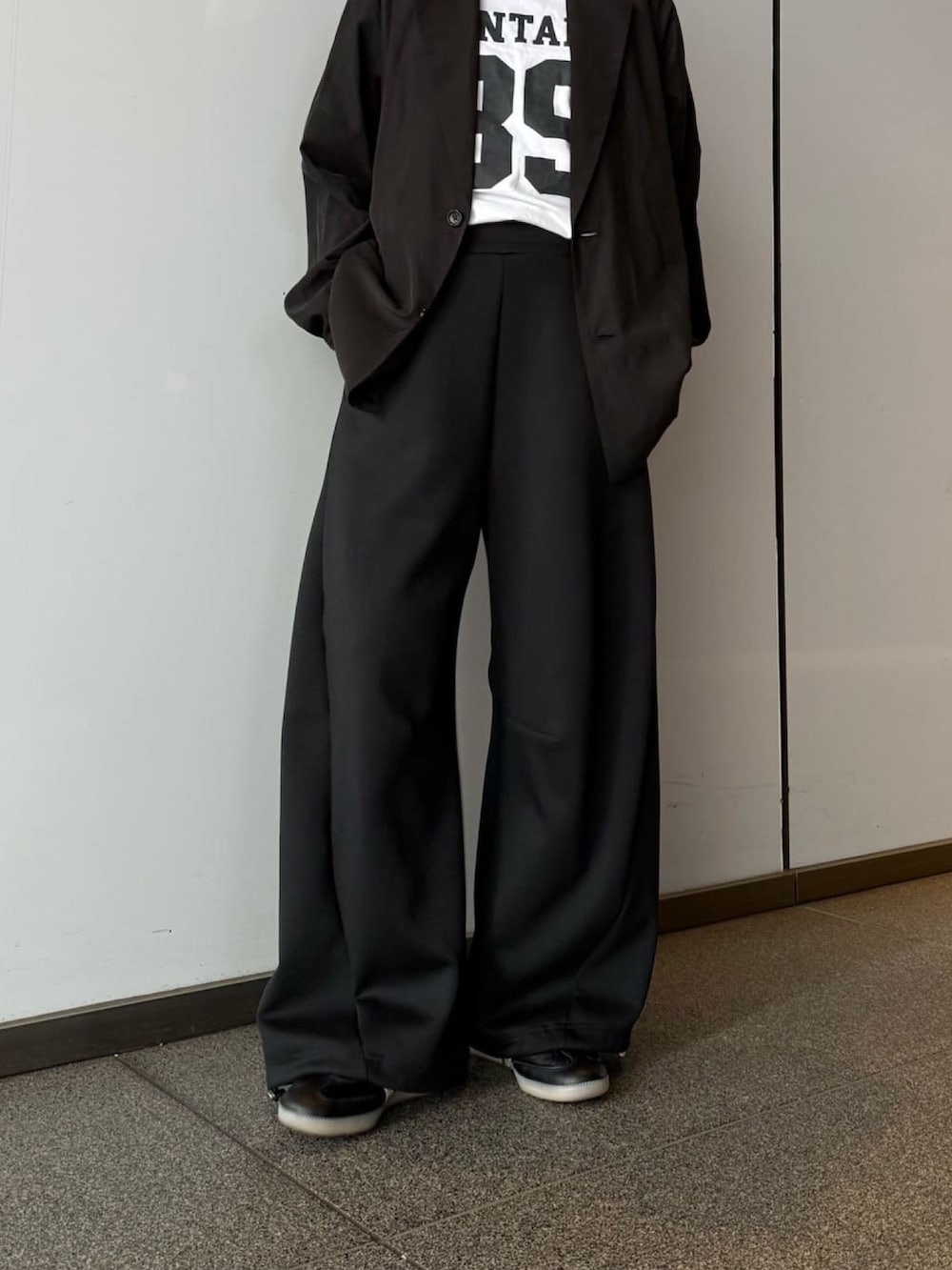 グレー系のその他パンツ、ブラック系のシャツ/ブラウス、ブラック系のサングラスを着用したレディースの春コーディネートの3枚目の写真