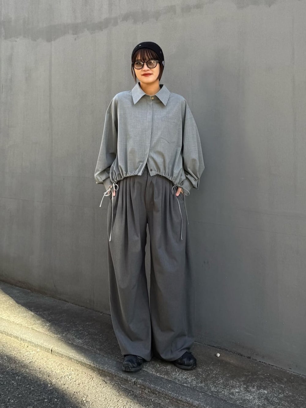 グレー系のスラックス、グレー系のシャツ/ブラウス、ブラック系のサングラスを着用したレディースの冬コーディネートの4枚目の写真