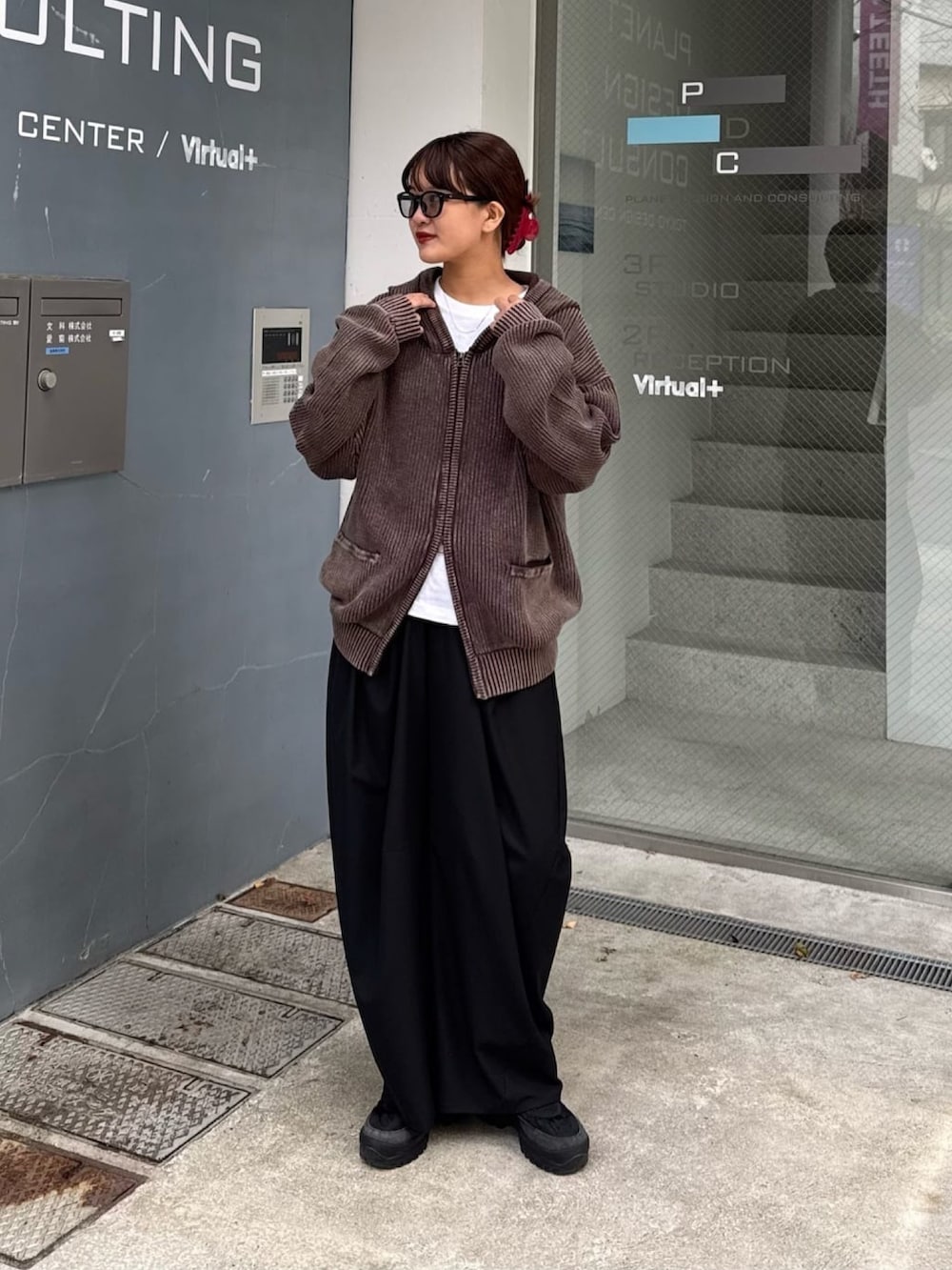 ブラウン系のパーカー、グレー系のスラックスを着用したレディースの春コーディネートの5枚目の写真