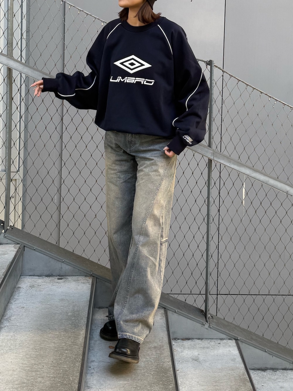 ブルー系のデニムパンツ、ブルー系のスウェット、ブラック系のサングラスを着用したレディースの冬コーディネートの2枚目の写真