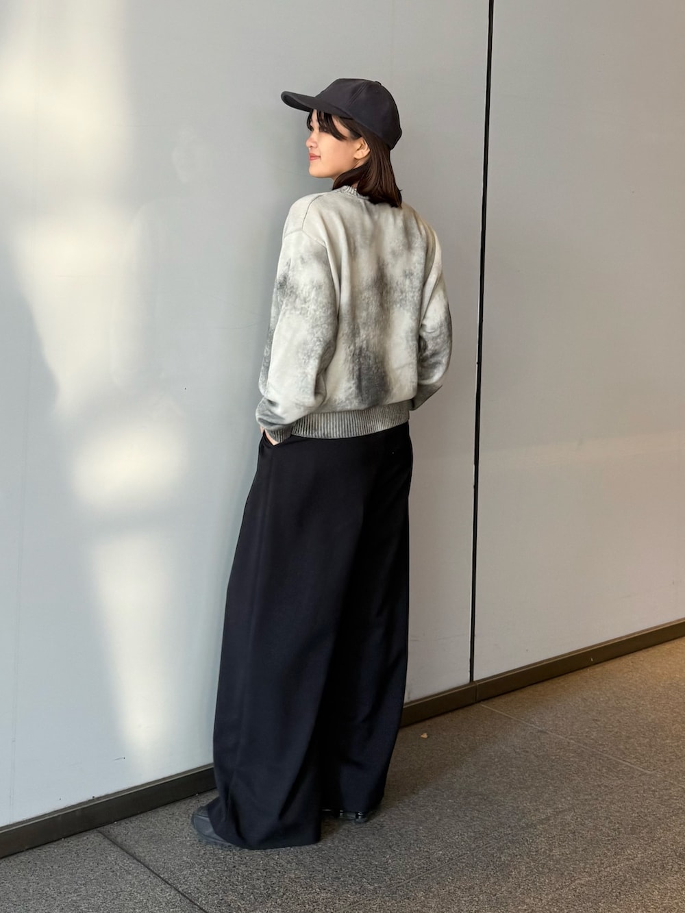 ホワイト系のニット/セーター、ブラック系のスラックスを着用したレディースの冬コーディネートの6枚目の写真