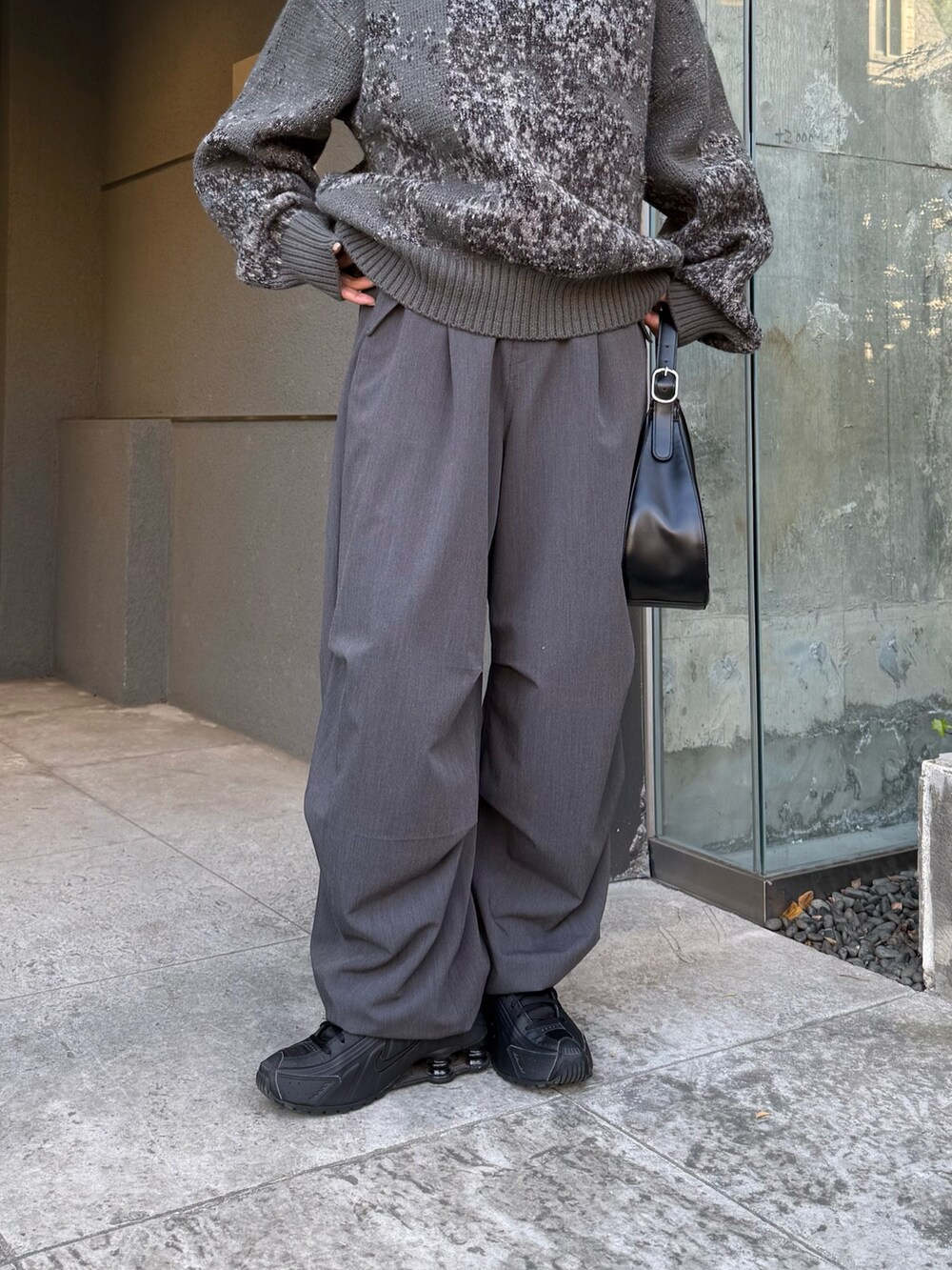 ブラック系のニット/セーター、グレー系のスラックス、ブラック系のハンドバッグを着用したレディースの冬コーディネートの7枚目の写真