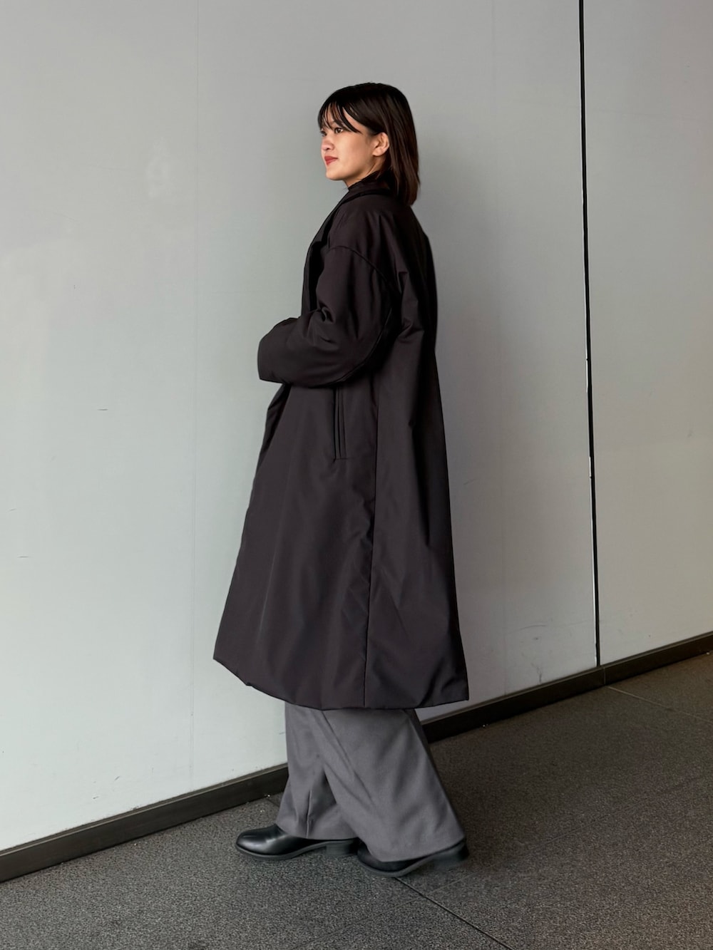 ブラック系のカーディガン/ボレロ、ブラック系のチェスターコート、ブラック系のトートバッグを着用したレディースの秋コーディネートの5枚目の写真