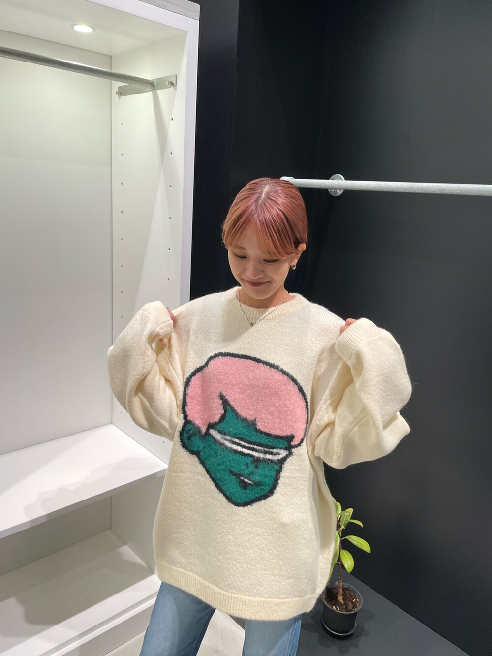 ホワイト系のニット/セーター、ブルー系のデニムパンツを着用したレディースの秋コーディネートの2枚目の写真