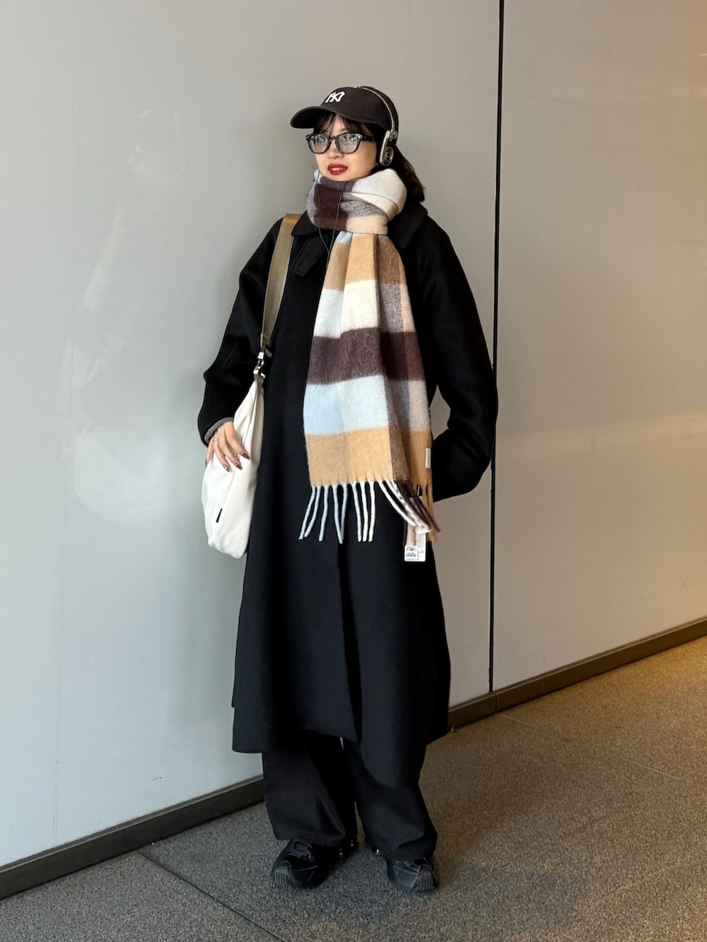 ブラック系のチェスターコート、ブラック系のその他アウター、ブラウン系のマフラーを着用したレディースの秋コーディネートの2枚目の写真