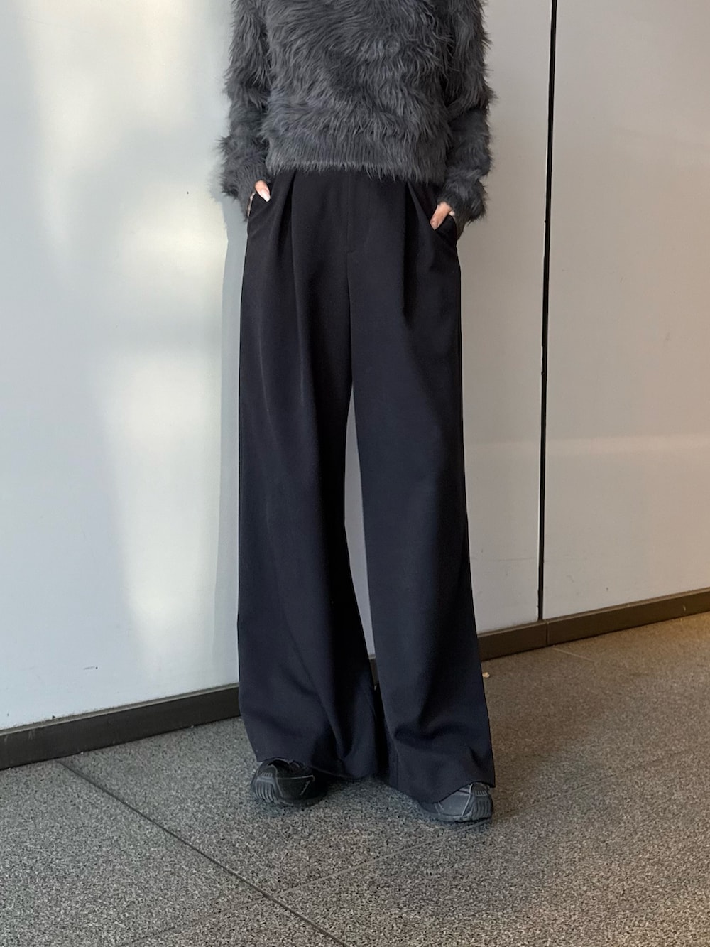 グレー系のニット/セーター、ブラック系のスラックスを着用したレディースの冬コーディネートの3枚目の写真