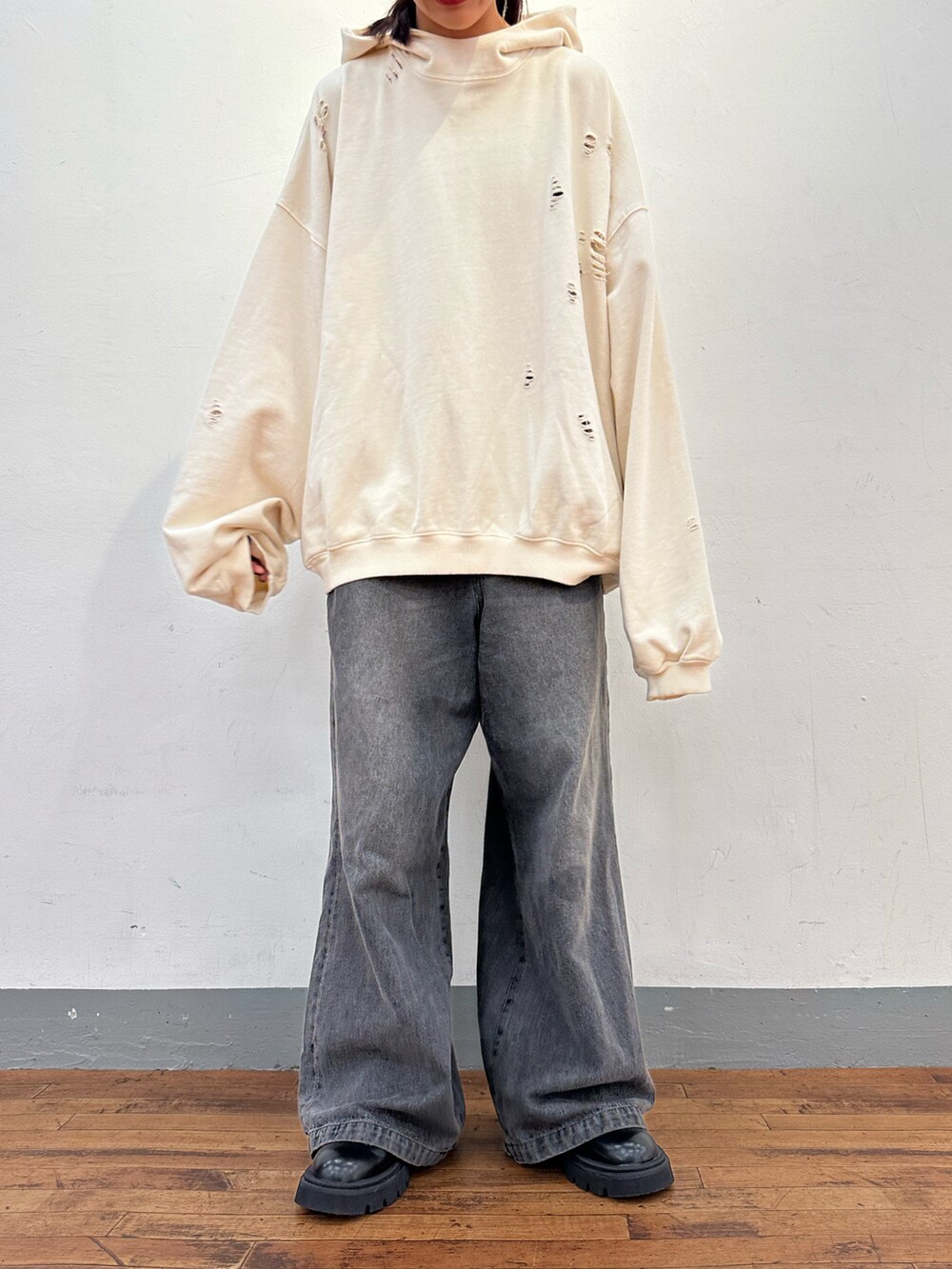 ホワイト系のパーカー、ブラック系のデニムパンツを着用したレディースの秋コーディネートの3枚目の写真