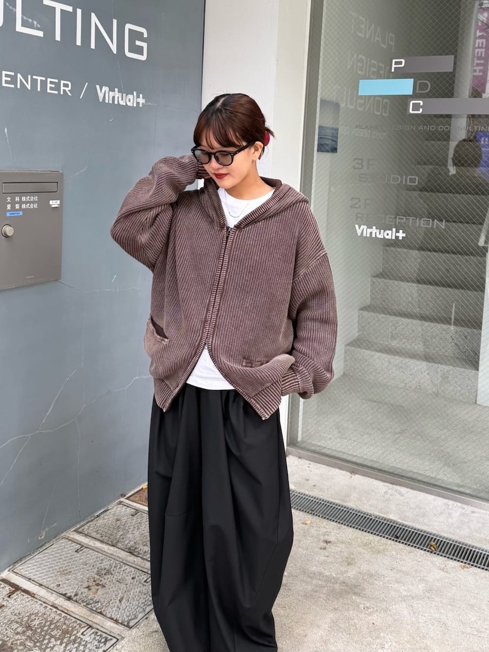 ブラウン系のパーカー、グレー系のスラックスを着用したレディースの春コーディネートの6枚目の写真