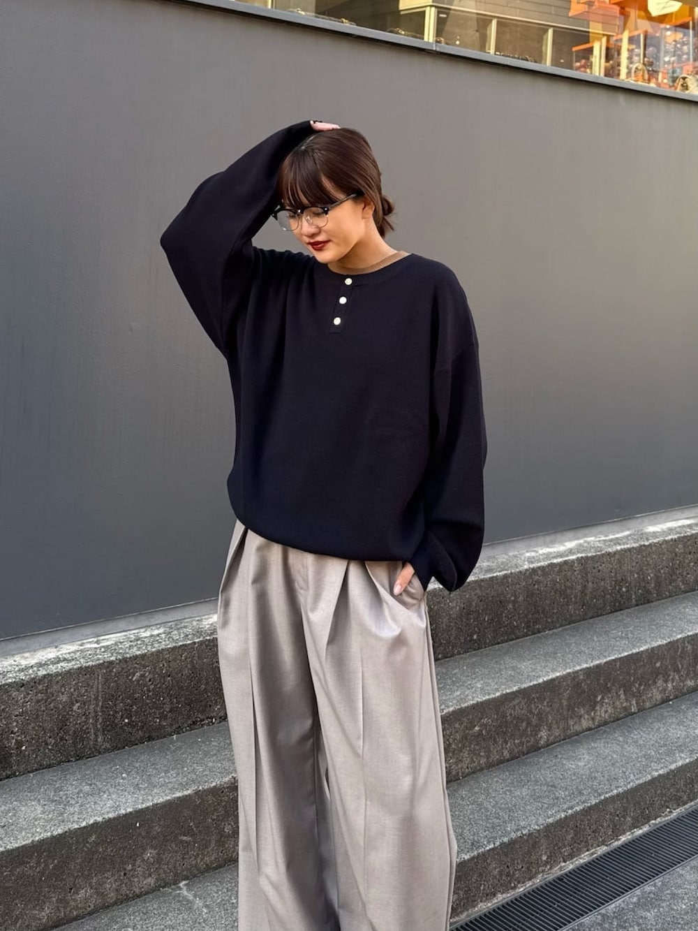 ブルー系のニット/セーター、グレー系のスラックスを着用したレディースの冬コーディネートの3枚目の写真