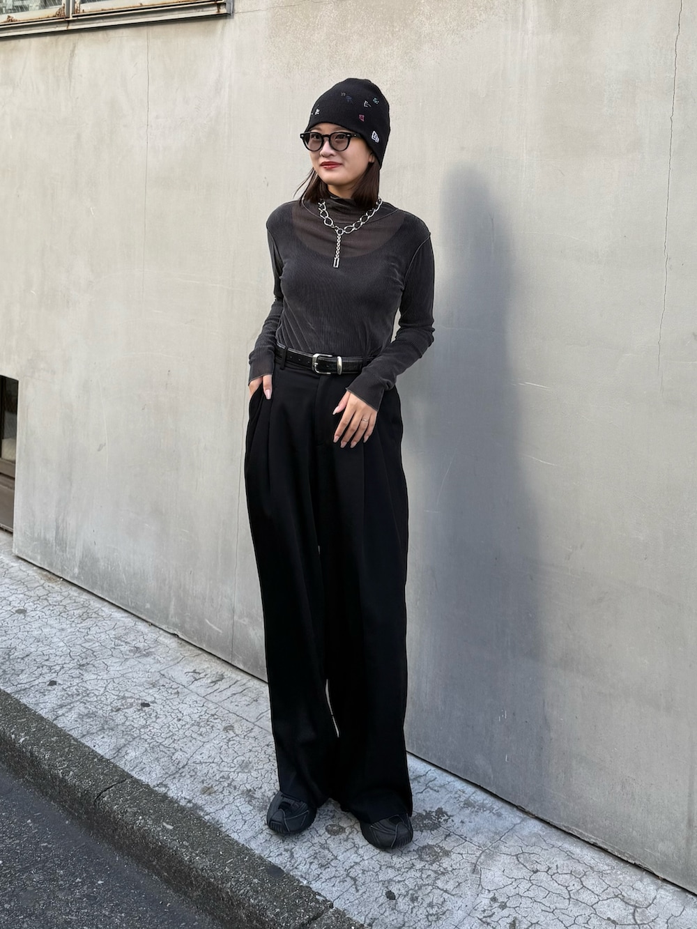 グリーン系のTシャツ/カットソー、ブラック系のスラックス、ブラック系のベルトを着用したレディースの秋コーディネートの5枚目の写真