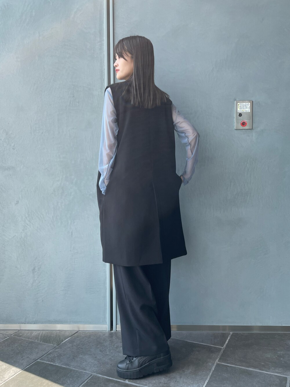 ブラック系のベスト、ホワイト系のキャミソール、ブラック系のその他パンツを着用したレディースの秋コーディネートの3枚目の写真