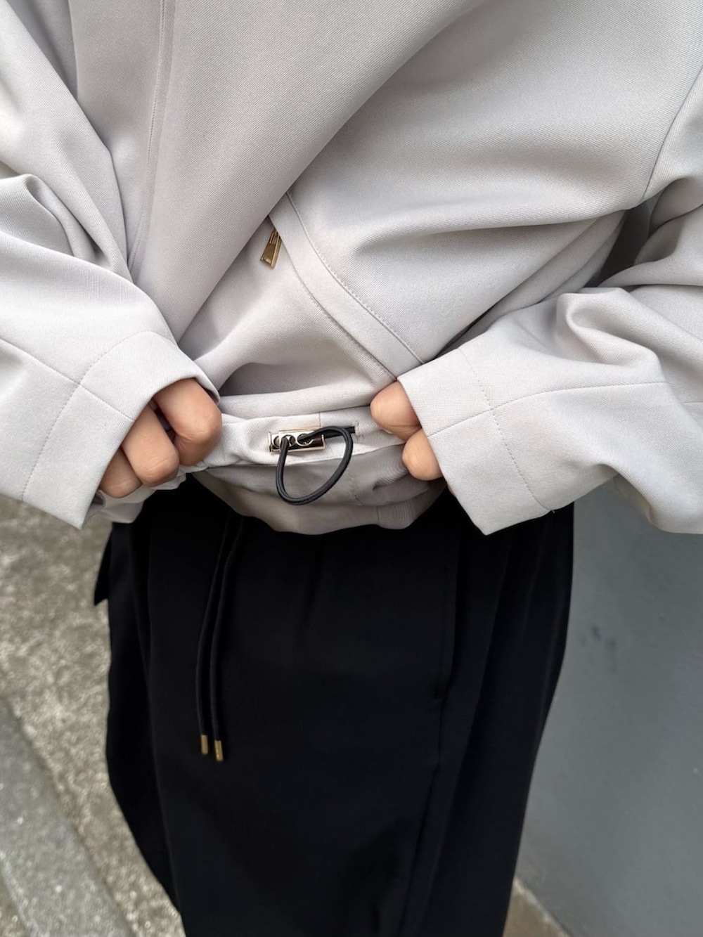 グレー系のブルゾン、ホワイト系のカーゴパンツを着用したレディースの冬コーディネートの7枚目の写真