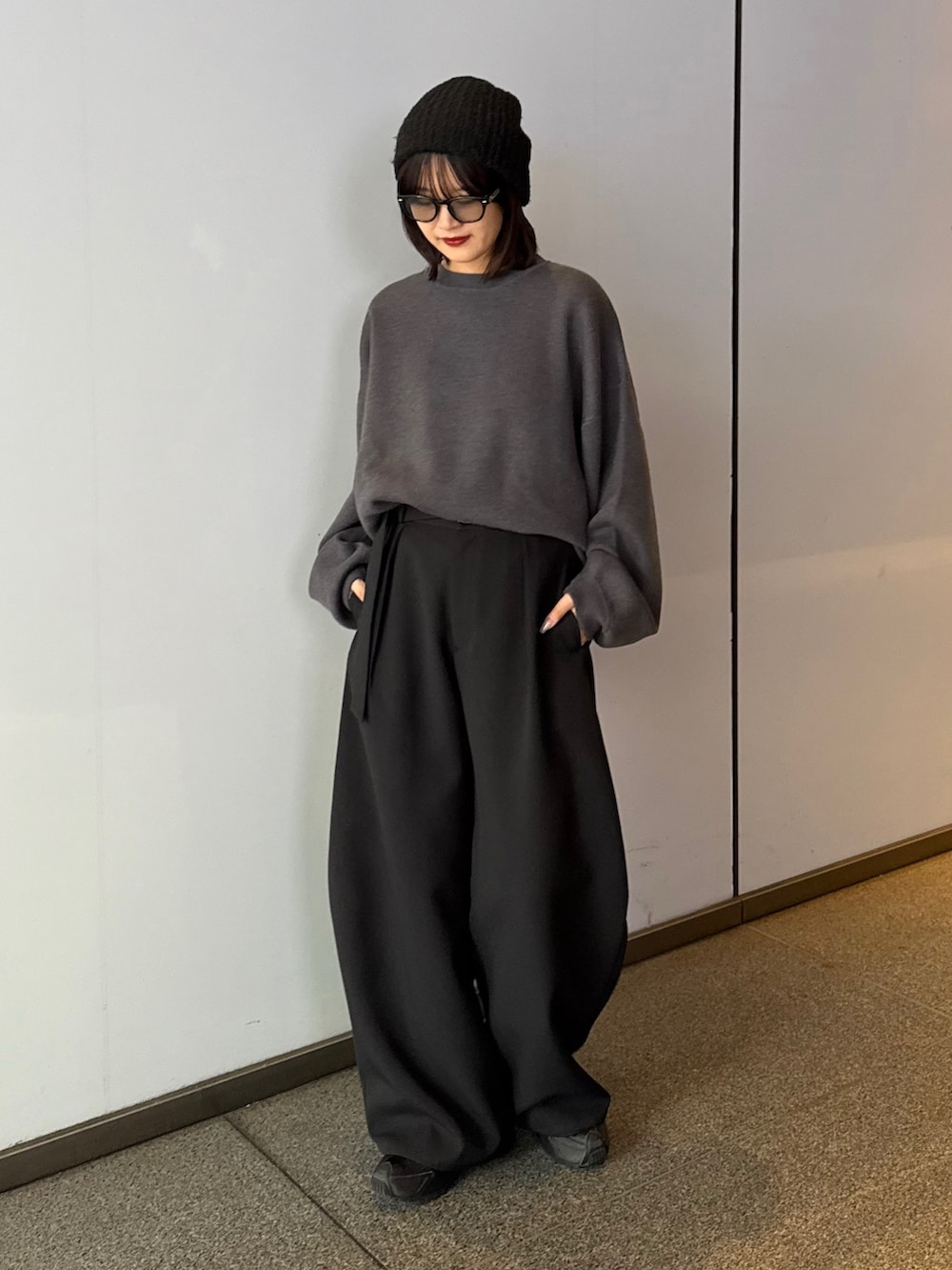 ブラック系のステンカラーコート、ブラック系のステンカラーコート、グレー系のニット/セーターを着用したレディースの秋コーディネートの6枚目の写真