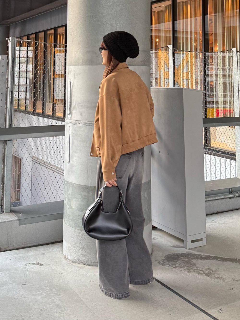 ブラウン系のブルゾン、ブラック系のデニムパンツ、ブラック系のベルトを着用したレディースの秋コーディネートの4枚目の写真