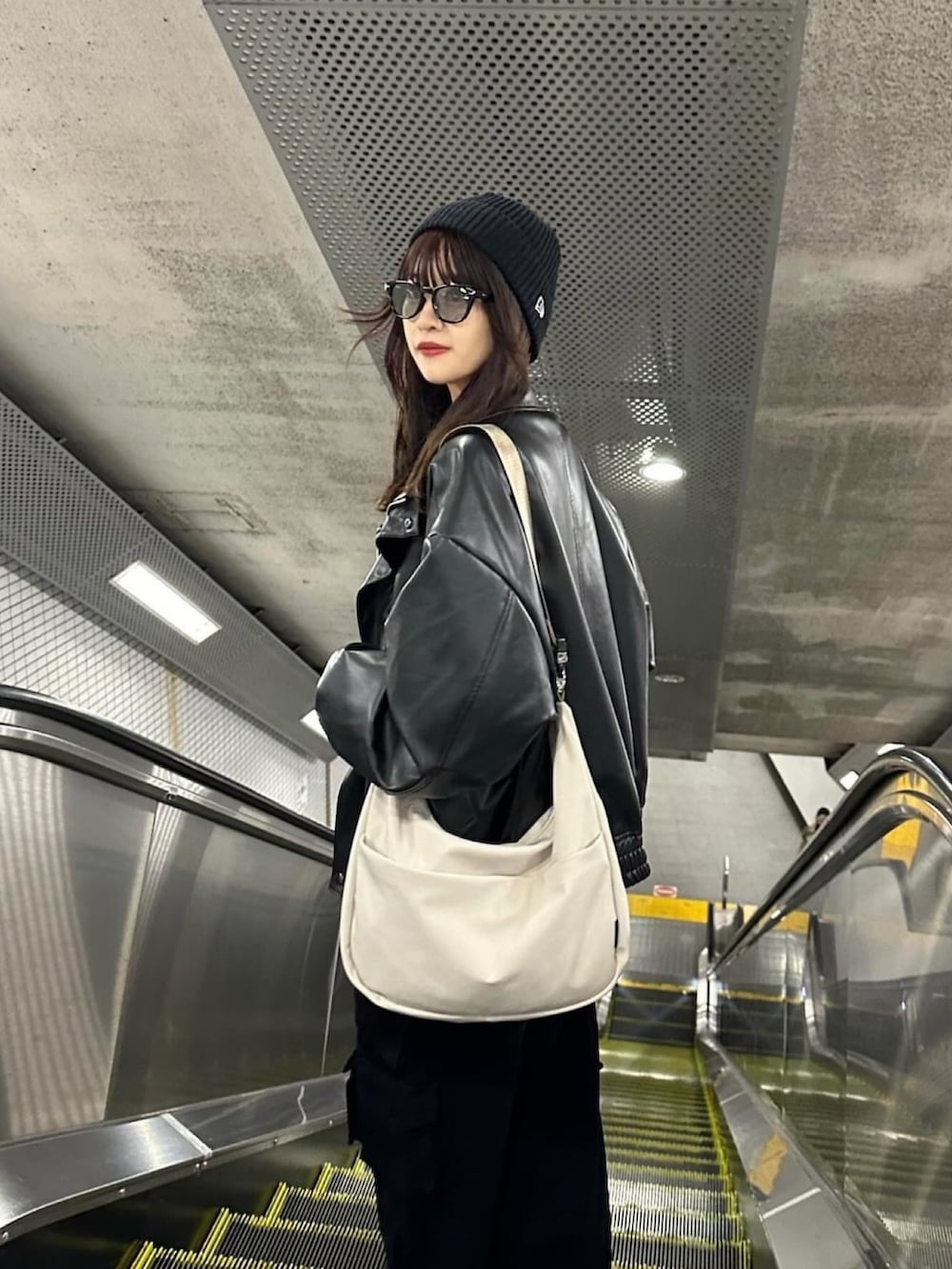 ホワイト系のショルダーバッグ、グレー系のトップス、ブラック系のジャケット/アウターを着用したレディースの冬コーディネートの3枚目の写真