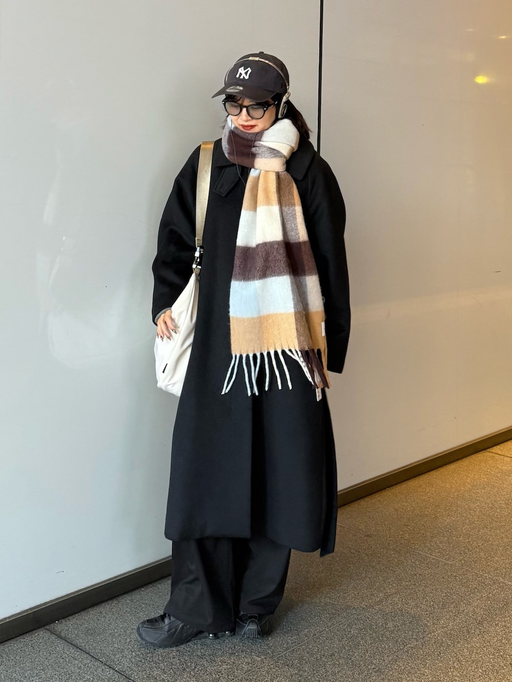 ブラック系のステンカラーコート、ブラック系のステンカラーコート、グレー系のショルダーバッグを着用したレディースの秋コーディネートの4枚目の写真