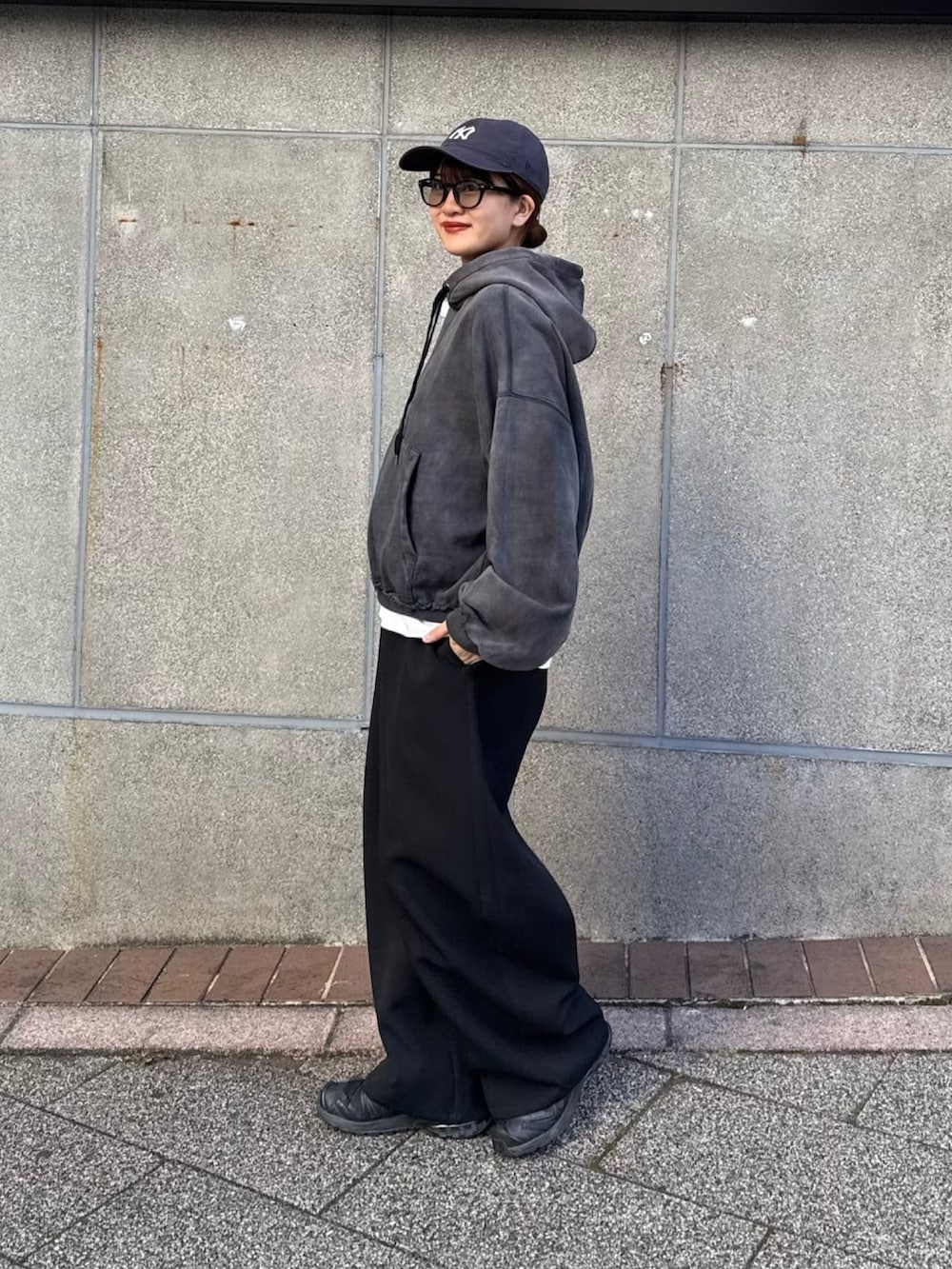 ブラック系のパーカー、ブラック系のスラックス、ブラック系のサングラスを着用したレディースの冬コーディネートの7枚目の写真