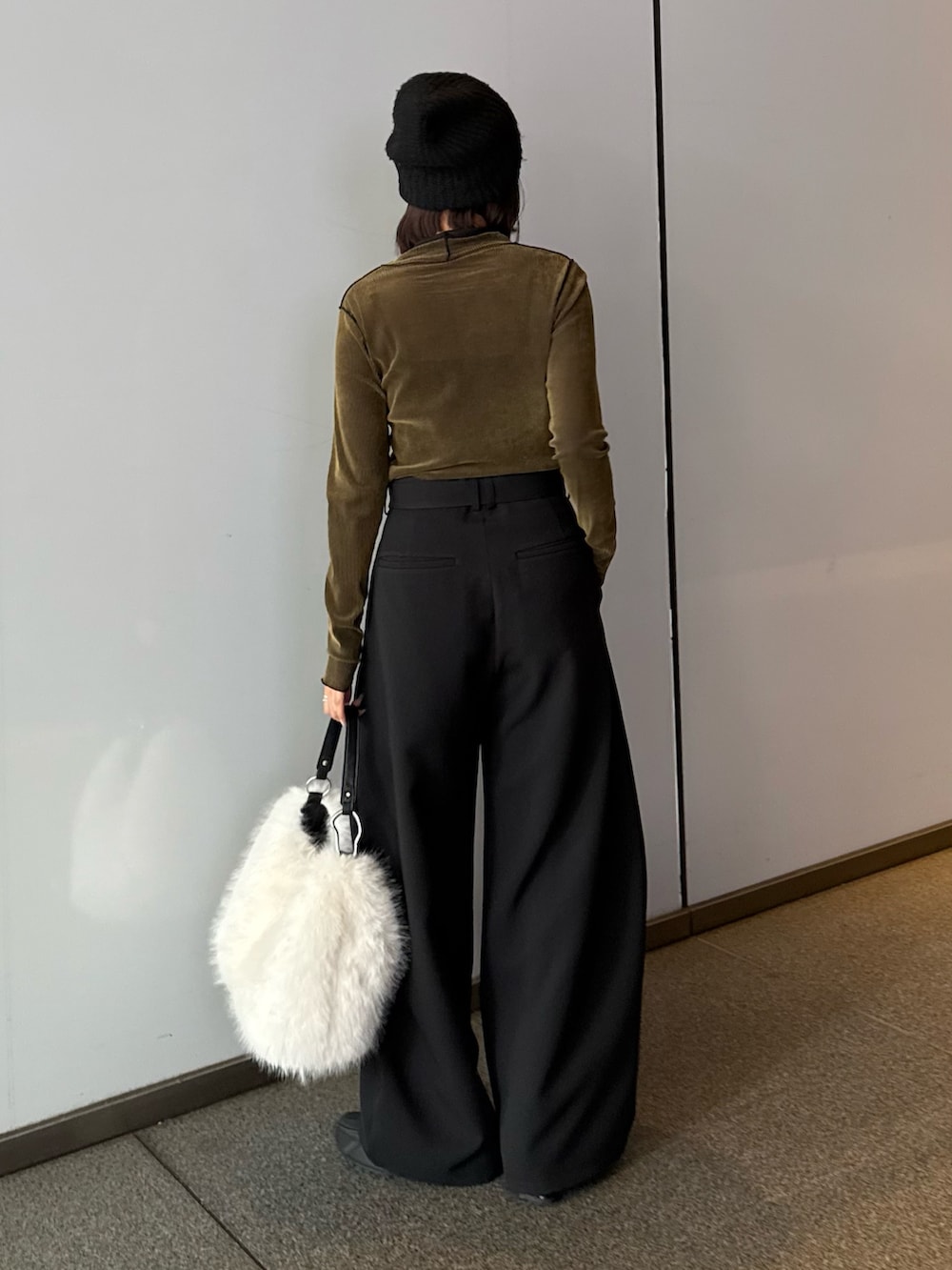 ブラック系のスラックス、ブラウン系のトートバッグ、グリーン系のTシャツ/カットソーを着用したレディースの秋コーディネートの3枚目の写真