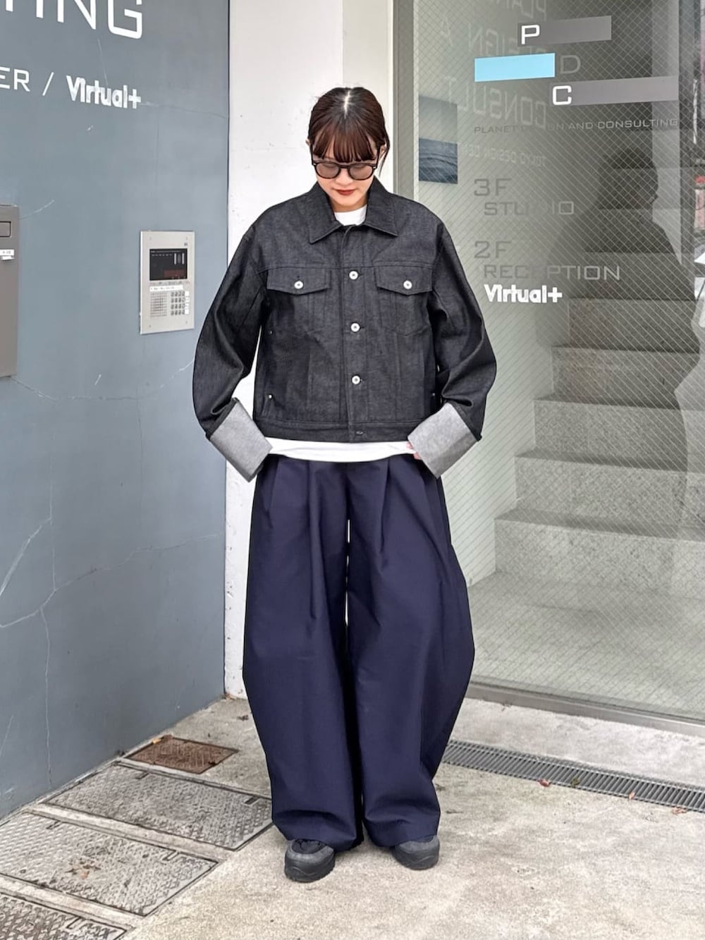 ブルー系のその他パンツ、ブラック系のデニムジャケット、ブラック系のサングラスを着用したレディースの春コーディネートの4枚目の写真