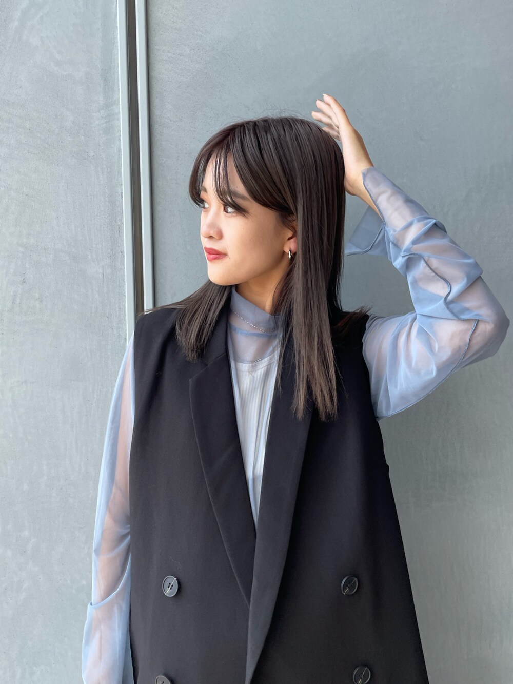 ブラック系のベスト、ホワイト系のキャミソール、ブラック系のその他パンツを着用したレディースの秋コーディネートの4枚目の写真