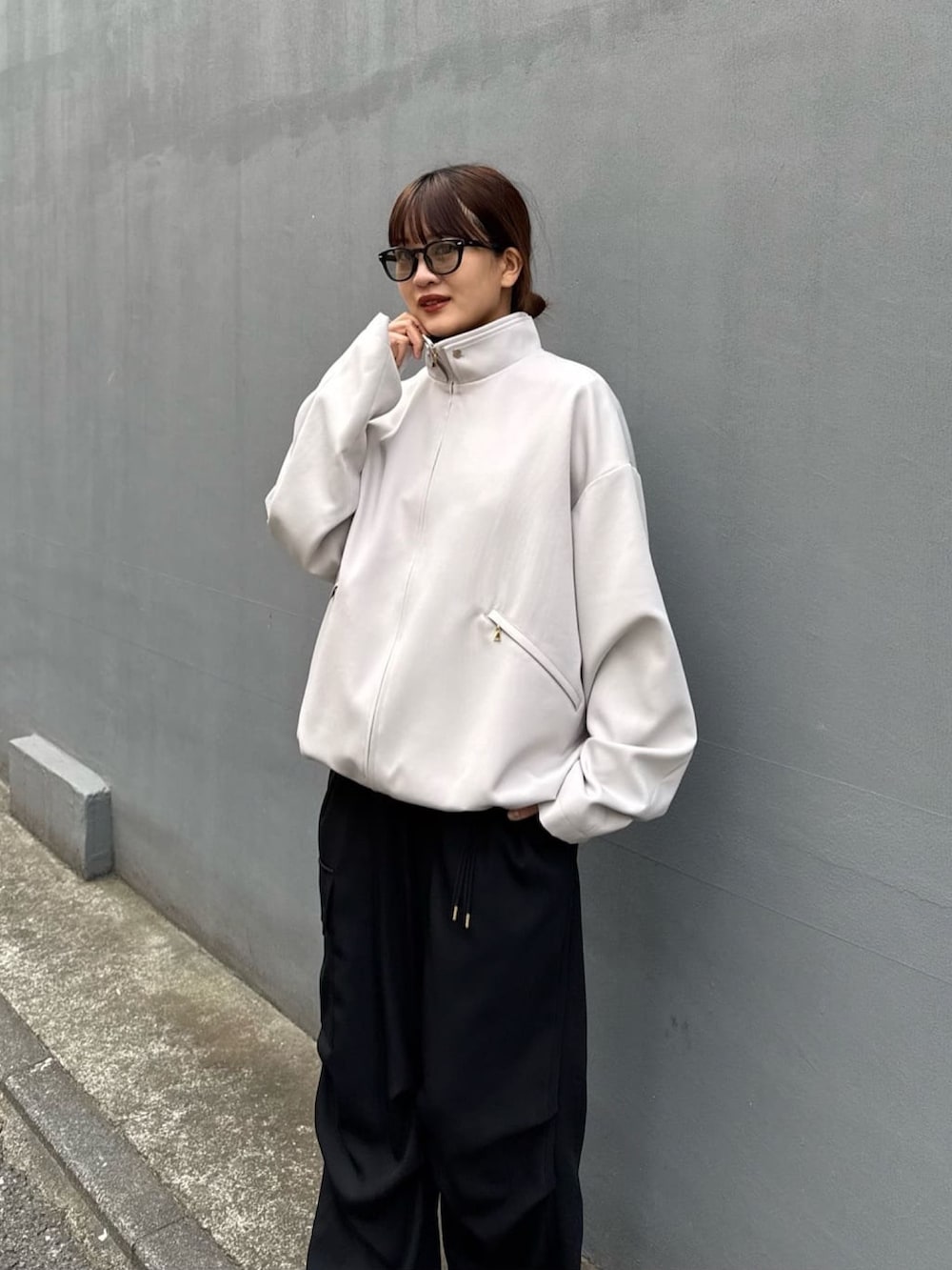 グレー系のブルゾン、ホワイト系のカーゴパンツを着用したレディースの冬コーディネートの3枚目の写真