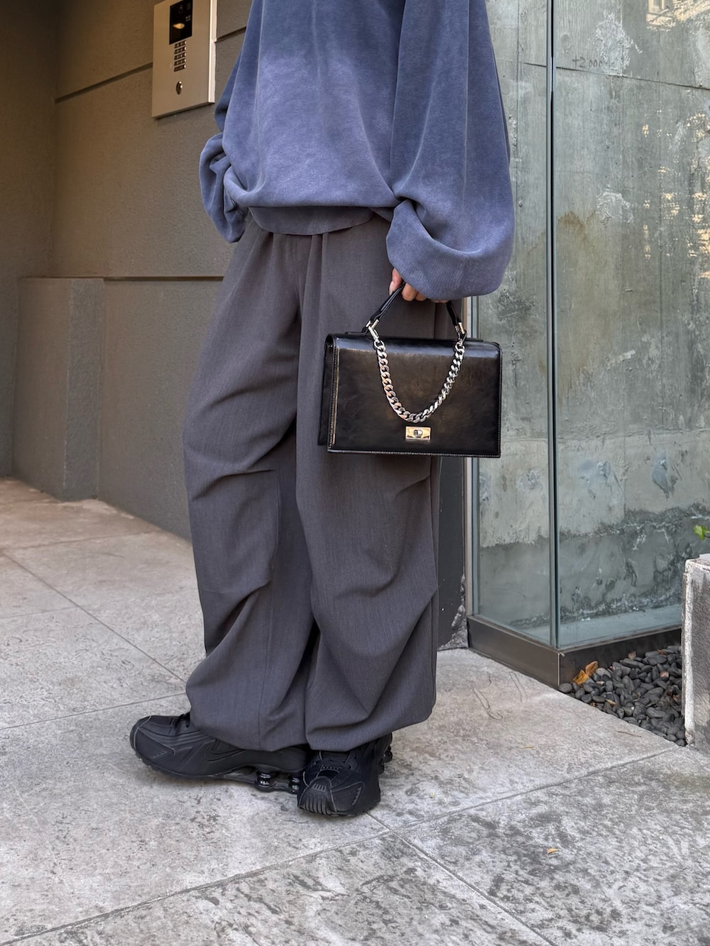 ブルー系のスウェット、ブラック系のショルダーバッグ、グレー系のスラックスを着用したレディースの冬コーディネートの6枚目の写真