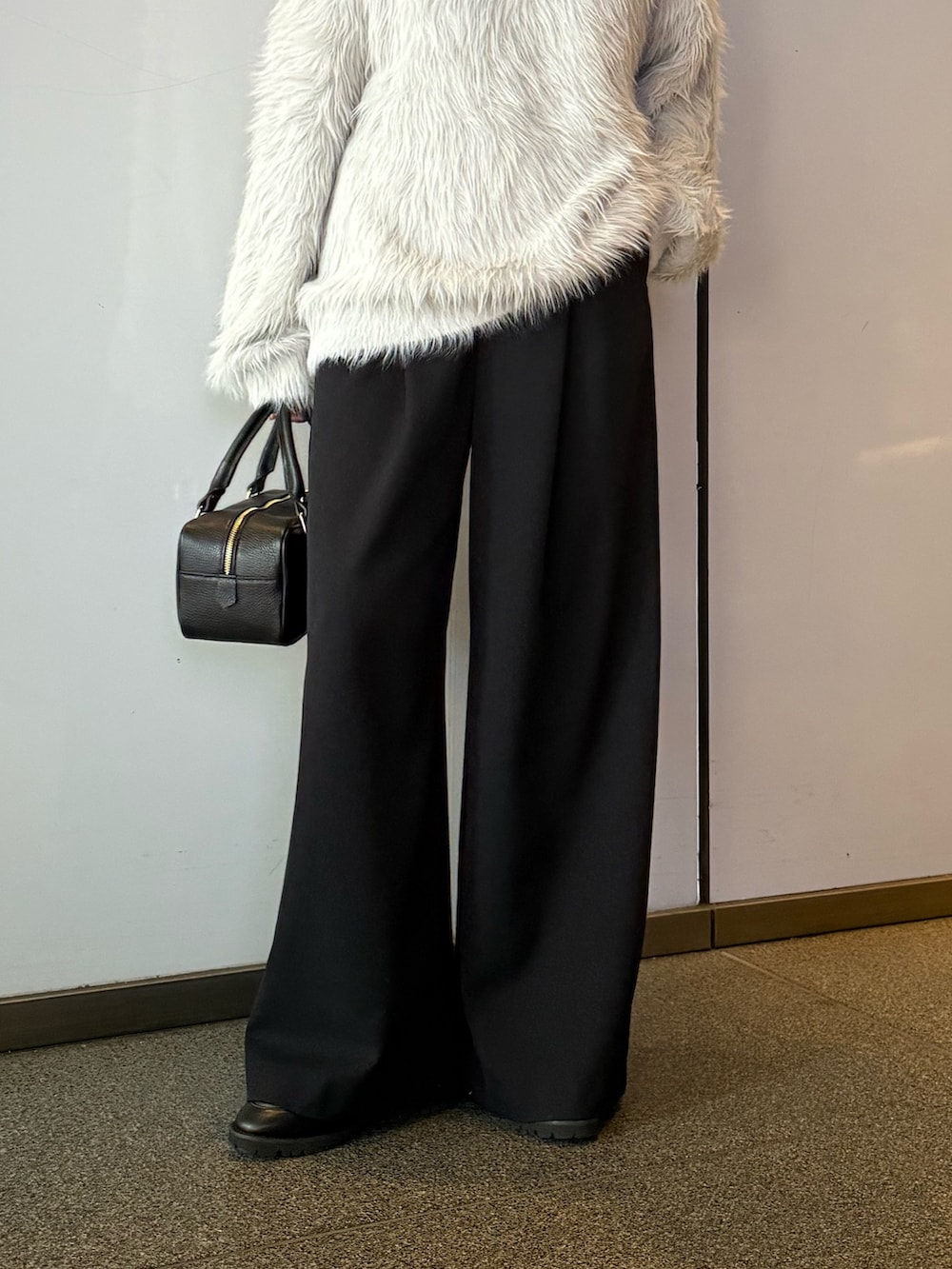 ブラック系のスラックス、ブラック系のトートバッグ、グレー系のニット/セーターを着用したレディースの冬コーディネートの5枚目の写真