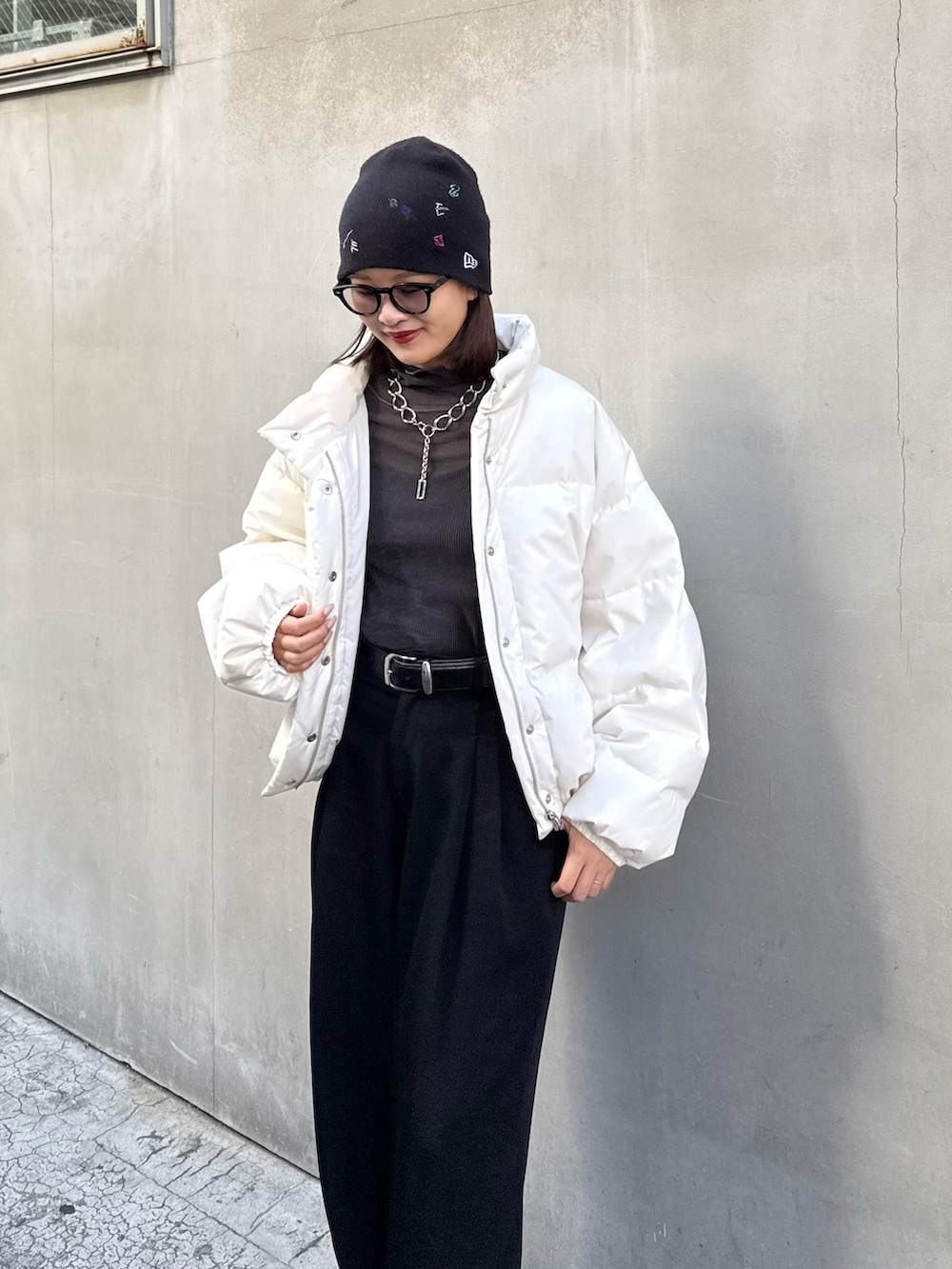 ホワイト系のダウンジャケット/コート、ブラック系のスラックス、ブラック系のベルトを着用したレディースの秋コーディネートの2枚目の写真