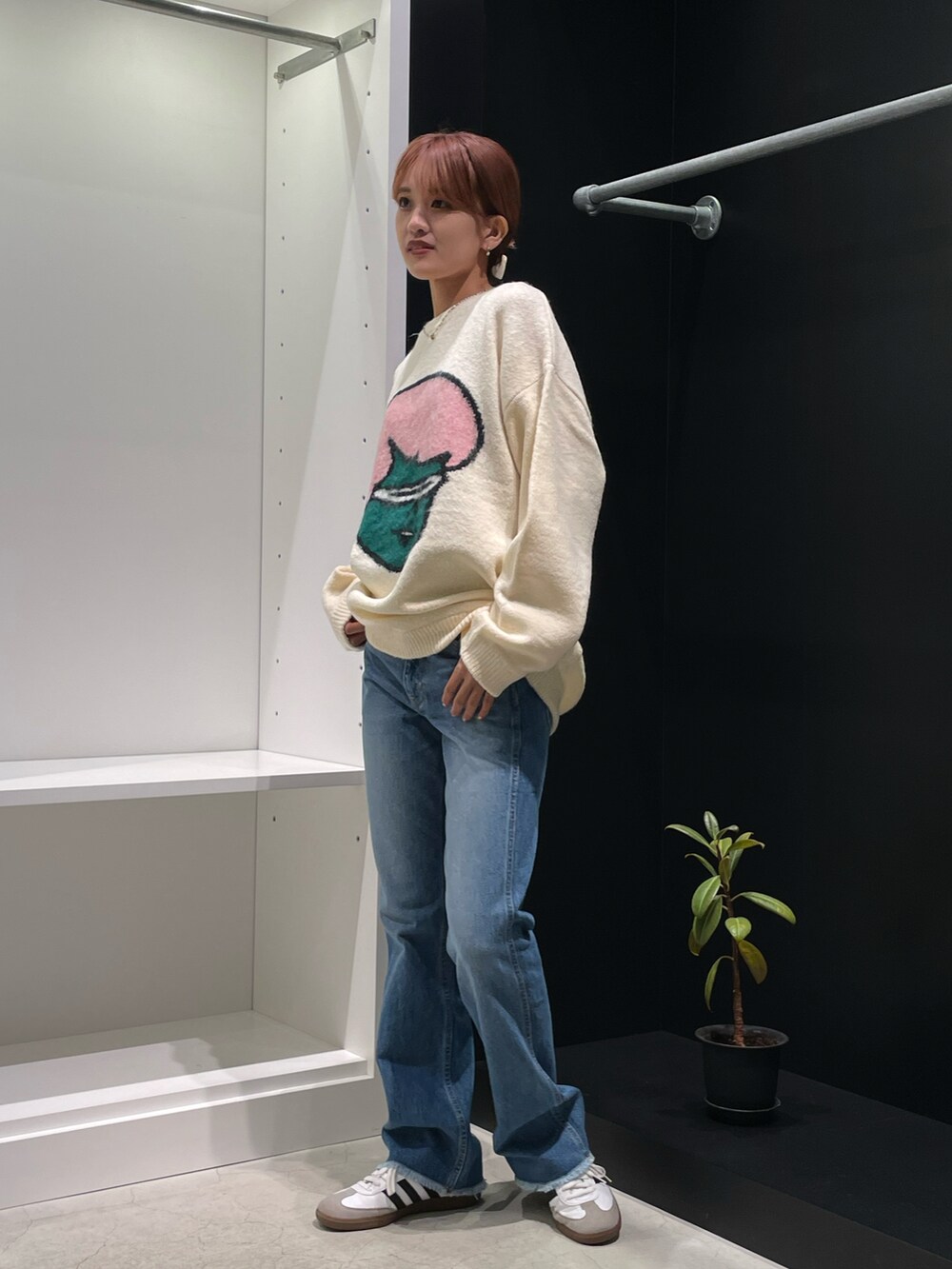 ホワイト系のニット/セーター、ブルー系のデニムパンツを着用したレディースの秋コーディネートの5枚目の写真