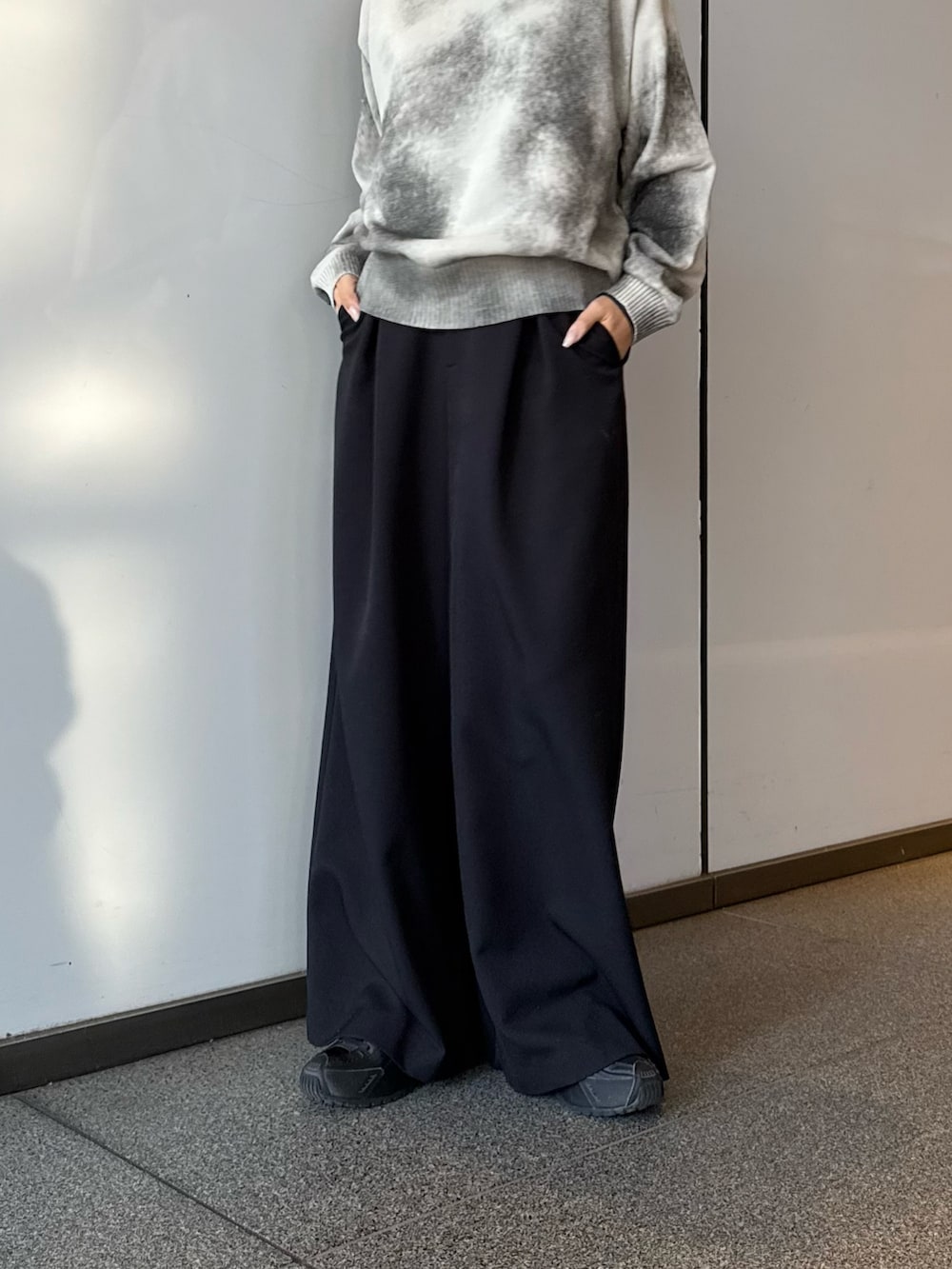 ホワイト系のニット/セーター、ブラック系のスラックスを着用したレディースの冬コーディネートの5枚目の写真