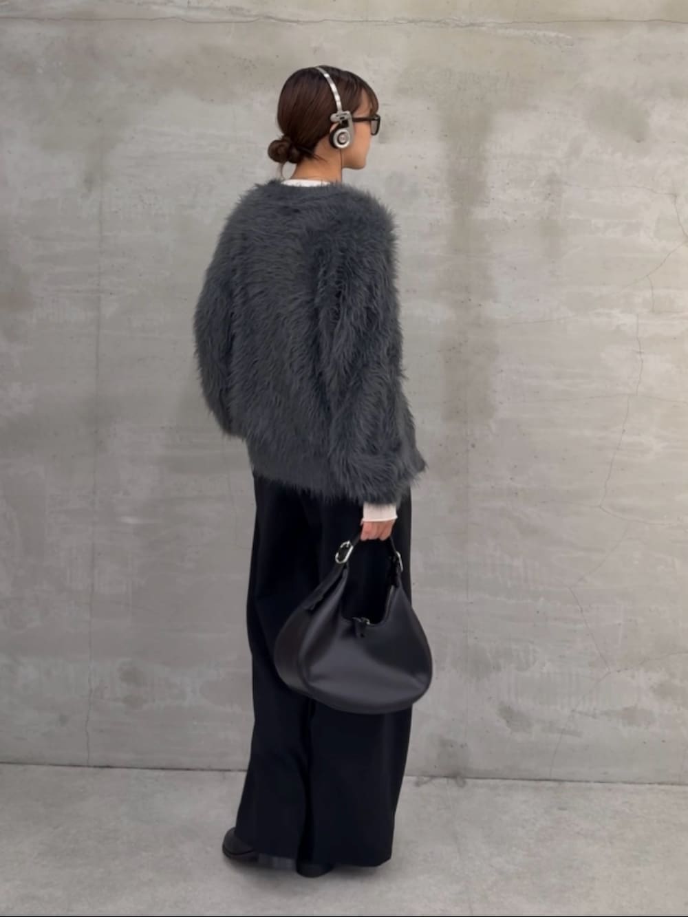 グレー系のカーディガン/ボレロ、ホワイト系のニット/セーター、ブラック系のスラックスを着用したレディースの秋コーディネートの3枚目の写真