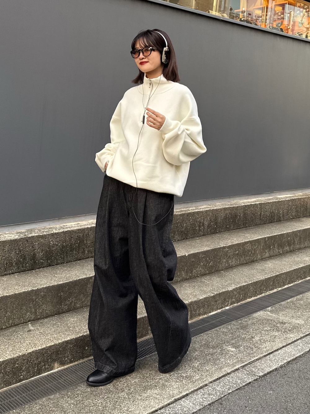 ホワイト系のニット/セーター、ブラック系のデニムパンツを着用したレディースの秋コーディネートの2枚目の写真