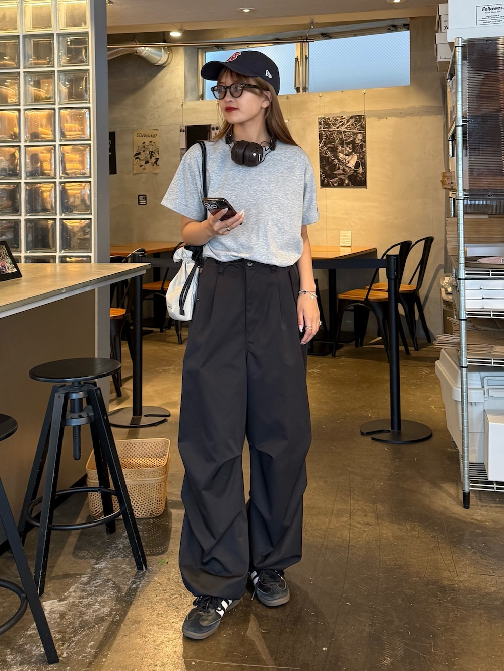 グレー系のTシャツ/カットソー、ブラック系のその他パンツ、ホワイト系のショルダーバッグを着用したレディースの夏コーディネートの2枚目の写真