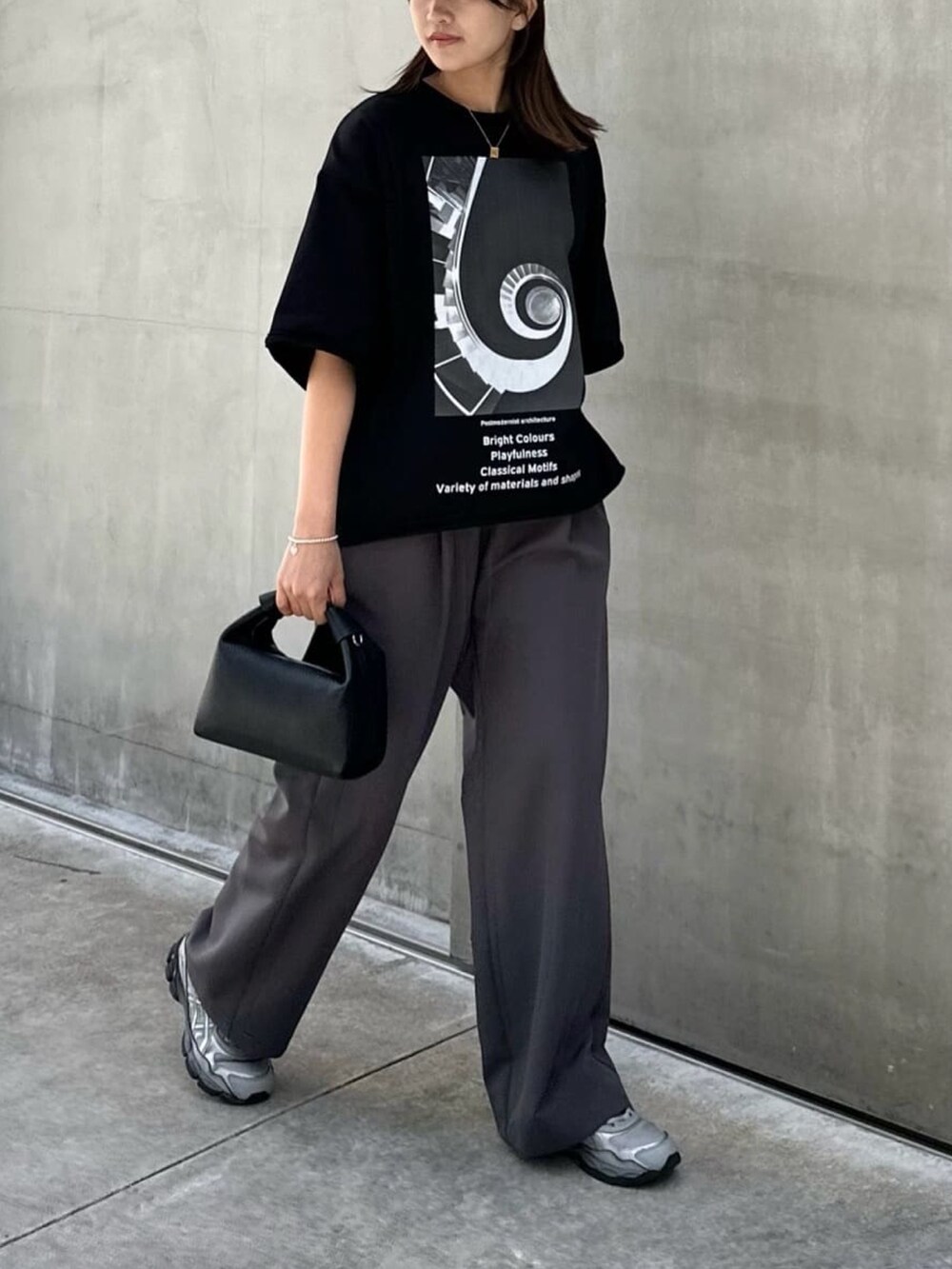 グレー系のパンツ、ブラック系のTシャツ/カットソー、ブラック系のバッグを着用したレディースの夏コーディネートの3枚目の写真