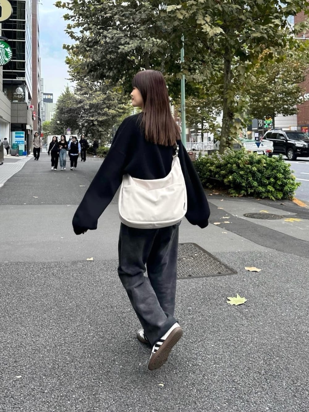 ホワイト系のバッグ、ブラック系のニット/セーターを着用したレディースの冬コーディネートの2枚目の写真