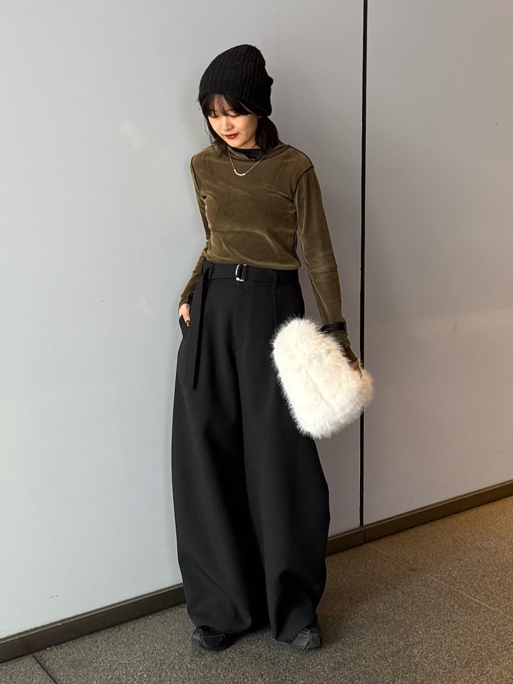 ブラック系のスラックス、ブラウン系のトートバッグ、グリーン系のTシャツ/カットソーを着用したレディースの秋コーディネートの4枚目の写真