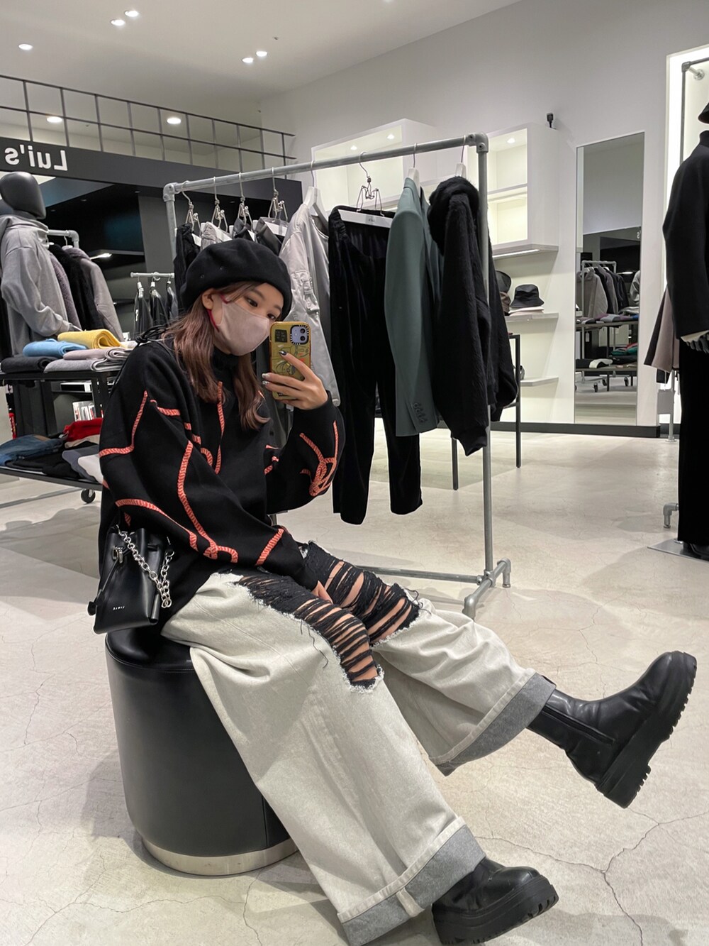 ブラック系のニット/セーター、ブラック系のボディバッグ/ウエストポーチ、ブルー系のデニムパンツを着用したレディースの冬コーディネートの3枚目の写真