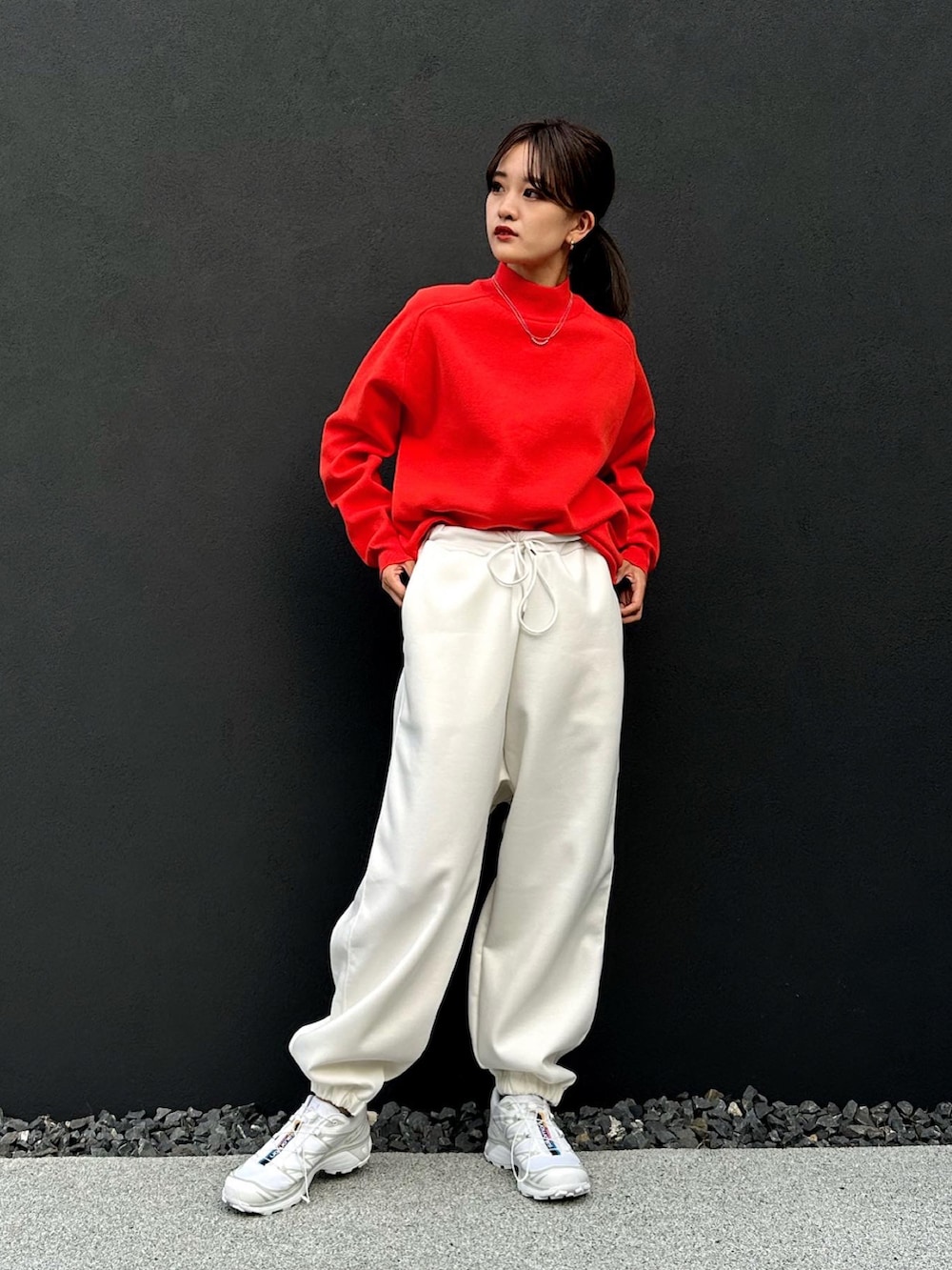 ホワイト系のスウェットパンツ、オレンジ系のニット/セーター、ホワイト系のスニーカーを着用したレディースの秋コーディネートの3枚目の写真