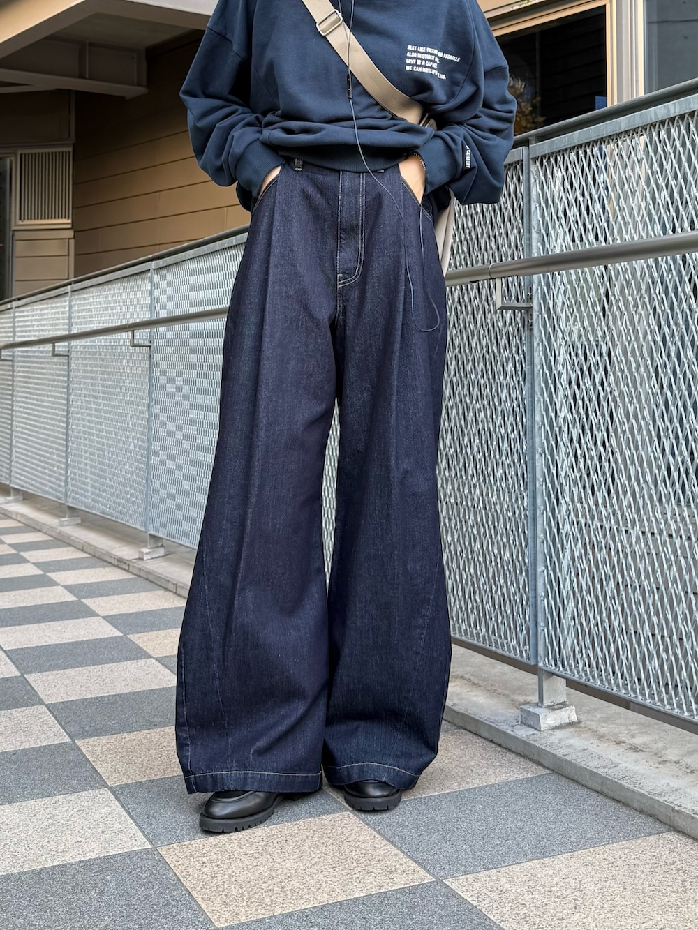 ブルー系のスウェット、グレー系のショルダーバッグ、ブルー系のデニムパンツを着用したレディースの冬コーディネートの3枚目の写真