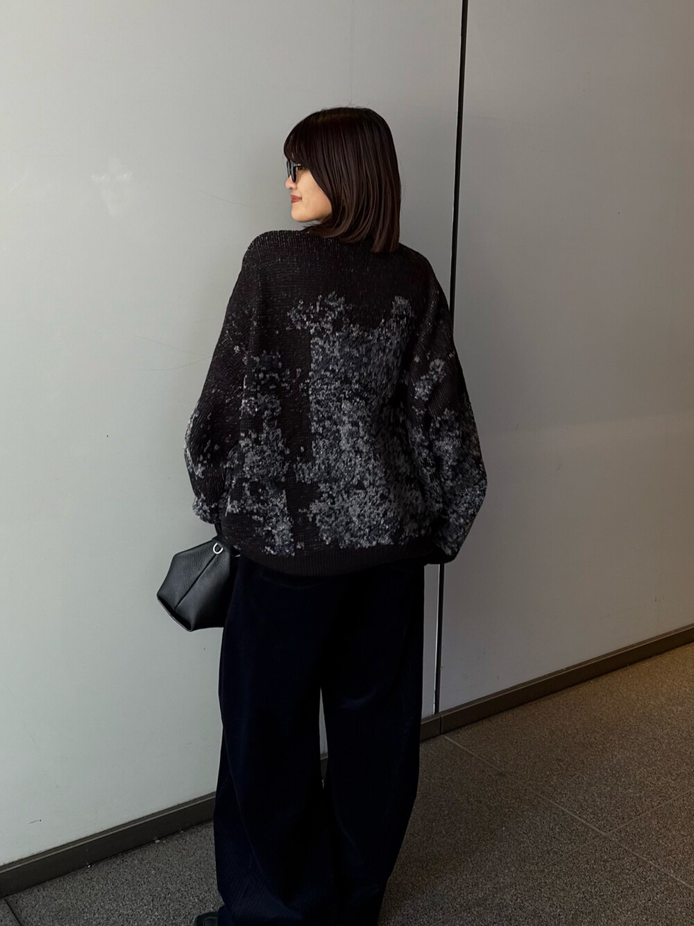 ブラック系のニット/セーター、ブラック系のトートバッグ、ブルー系のその他パンツを着用したレディースの秋コーディネートの6枚目の写真