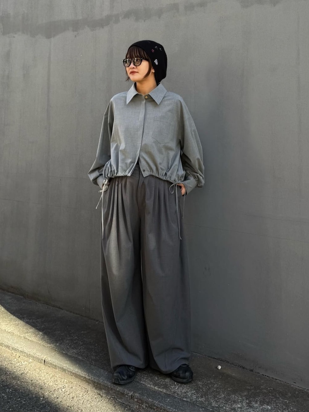 グレー系のスラックス、グレー系のシャツ/ブラウス、ブラック系のサングラスを着用したレディースの冬コーディネートの6枚目の写真