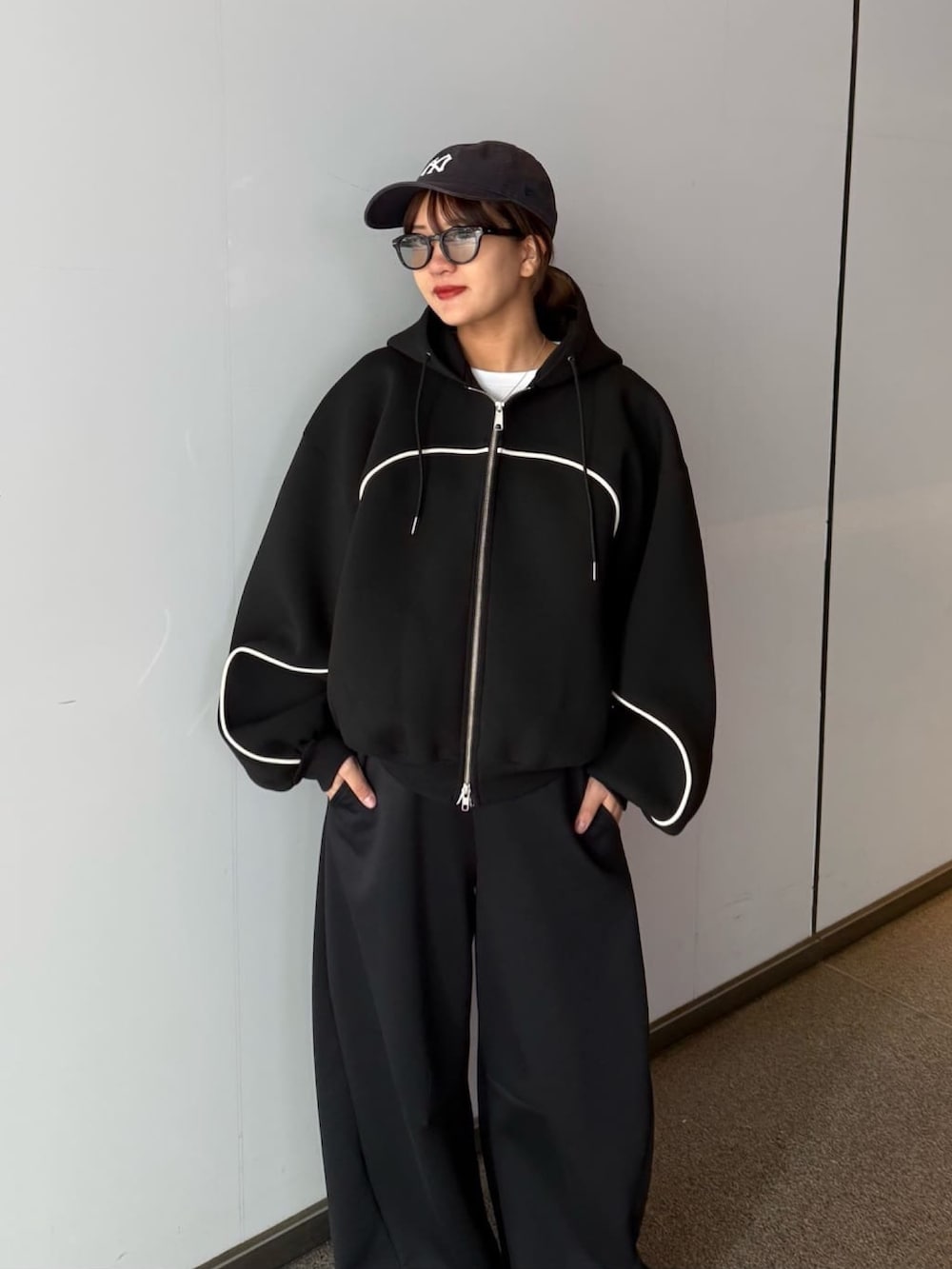 グレー系のその他パンツ、グレー系のパーカー、ブラック系のサングラスを着用したレディースの春コーディネートの2枚目の写真