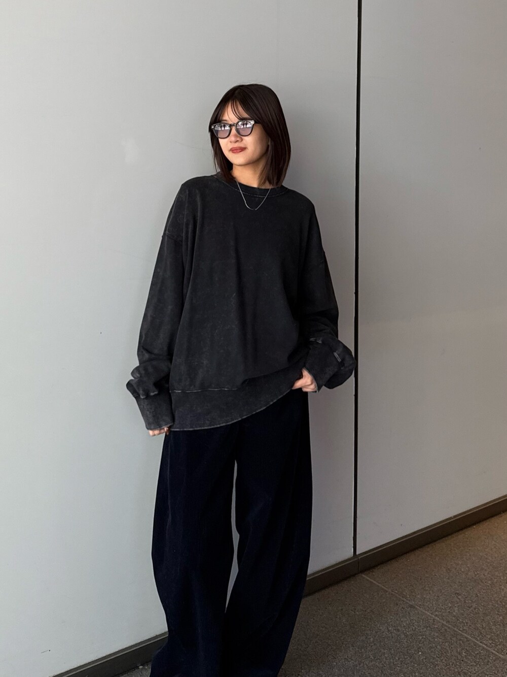 ブラック系のスウェット、ブルー系のその他パンツ、ブラック系のサングラスを着用したレディースの秋コーディネートの7枚目の写真