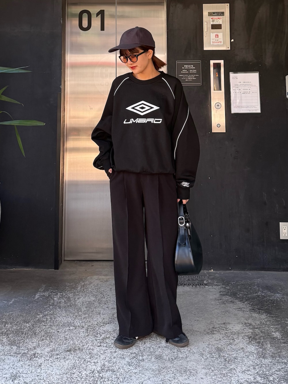 ブルー系のスウェット、ブラック系のハンドバッグ、ブラック系のサングラスを着用したレディースの冬コーディネートの6枚目の写真